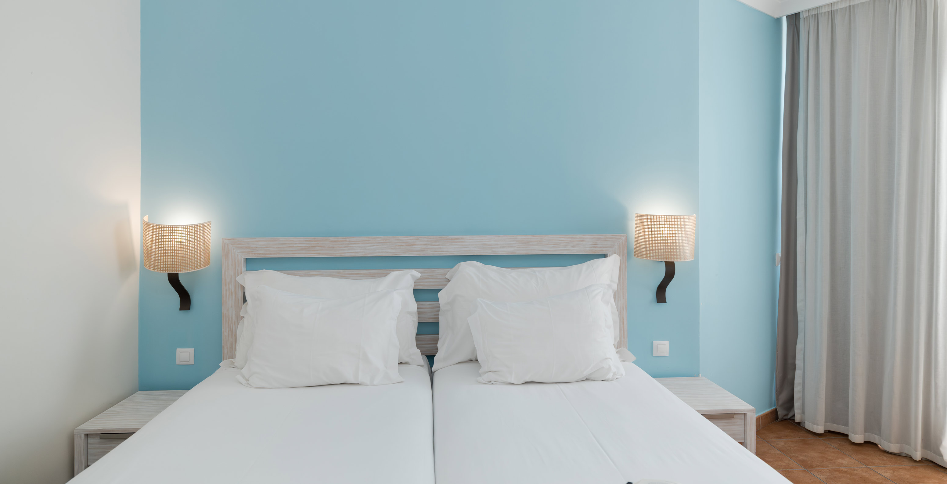 Le Deluxe Vue Jardin du Pestana Viking a deux lits, deux tables de chevet et du papier peint bleu