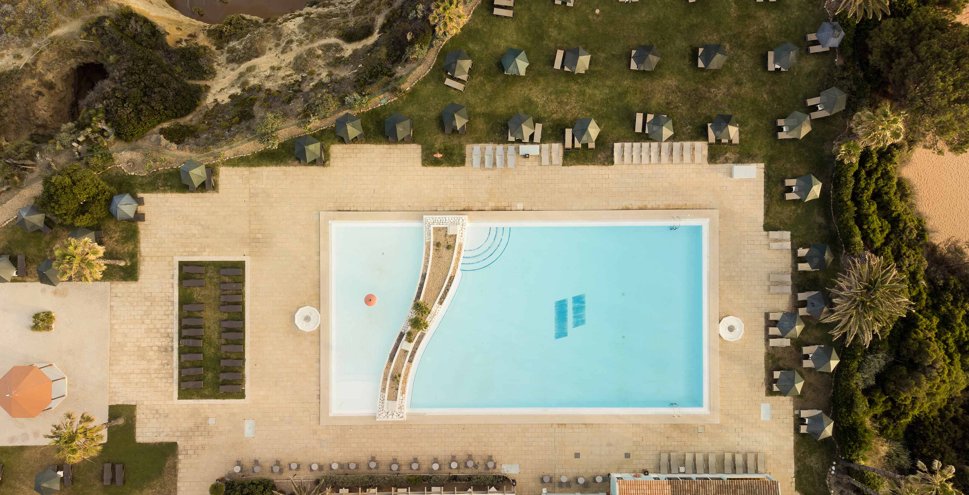 Piscine extérieure du Pestana Viking, entourée de végétation, avec transats et parasols