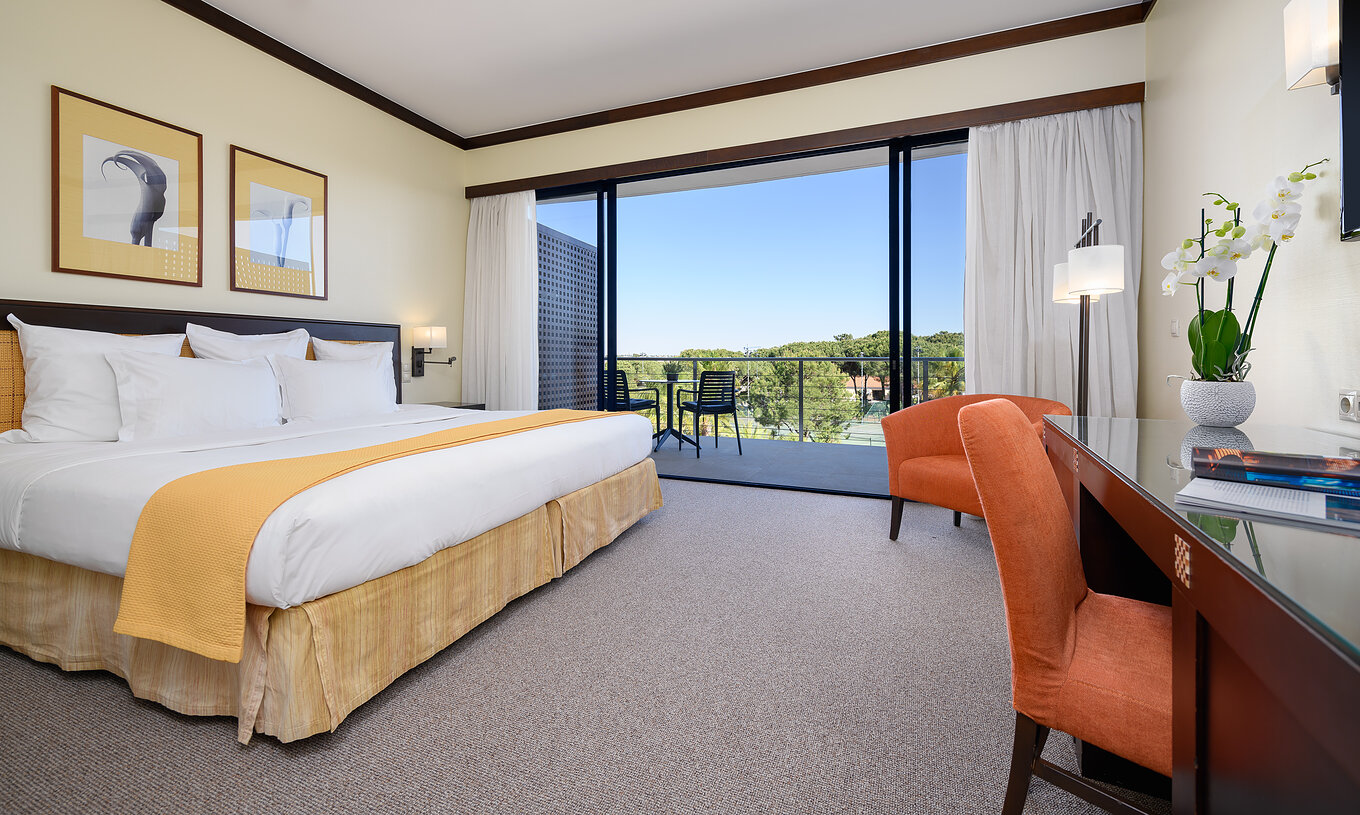 Le Supérieure du Pestana Vila Sol - Vilamoura a un lit double, un bureau, fauteuil et un balcon avec chaises
