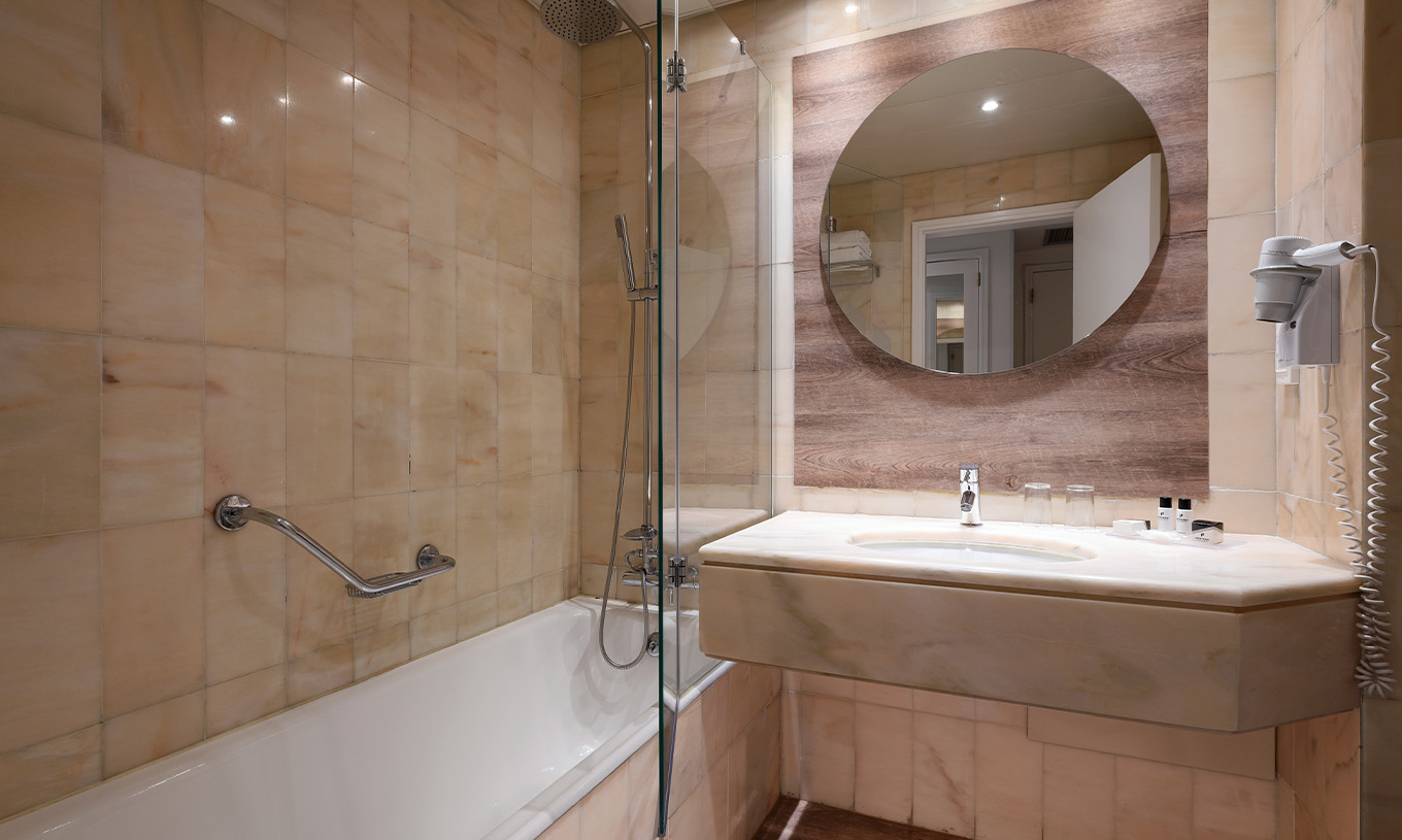 La Suite Deluxe Vue Mer du Pestana Cascais a une salle de bains avec miroir, lavabo et baignoire avec douche