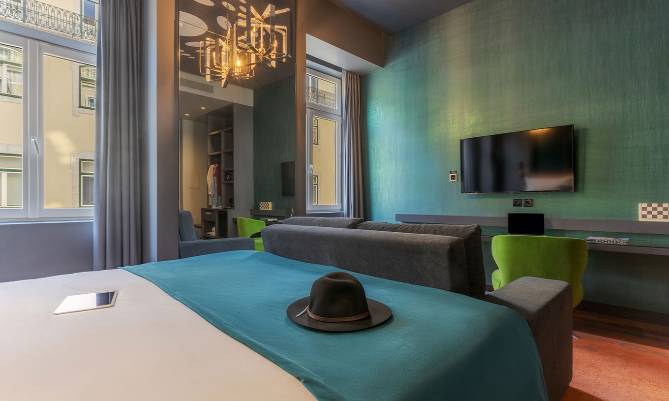 La chambre CR7 Familial Hat-Trick du Pestana CR7 Lisboa a un miroir, un canapé avec télévision et un lit