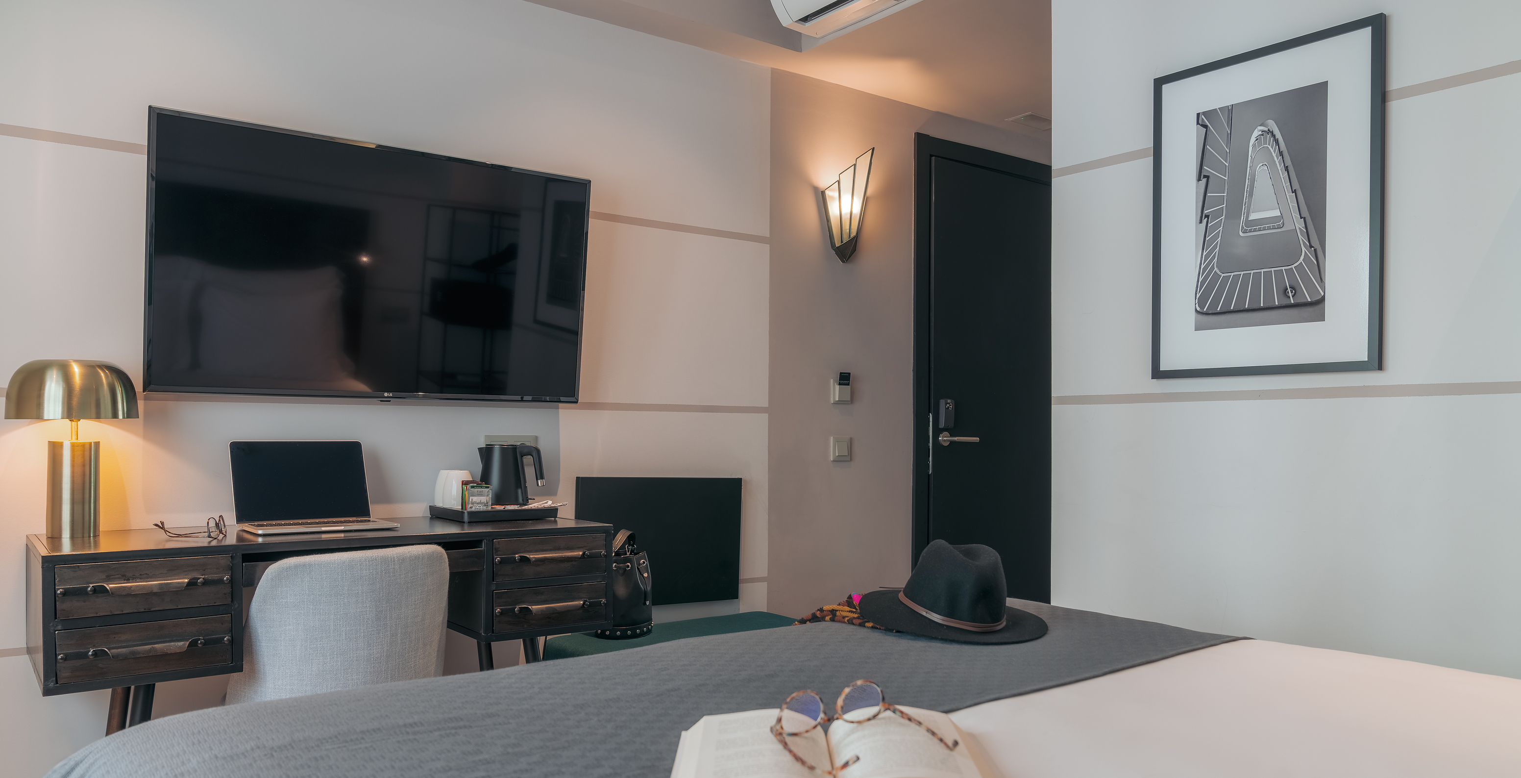 Le Vintage du Pestana Lisboa Vintage a un lit double avec une couverture grise un bureau avec ordinateur et télévision