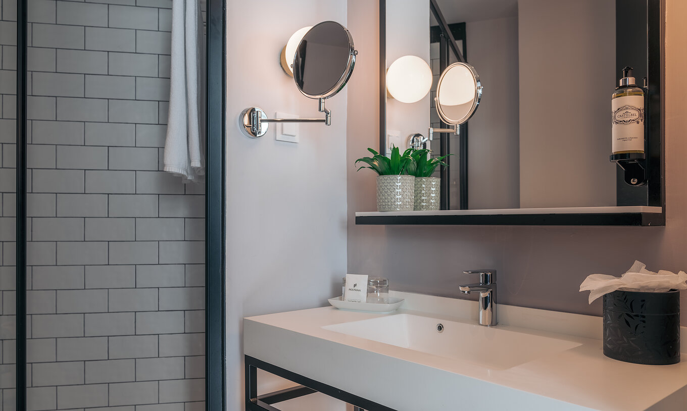 Le Double Supérieur du Pestana Lisboa Vintage a une salle de bain avec lavabo avec deux miroirs et une douche latérale