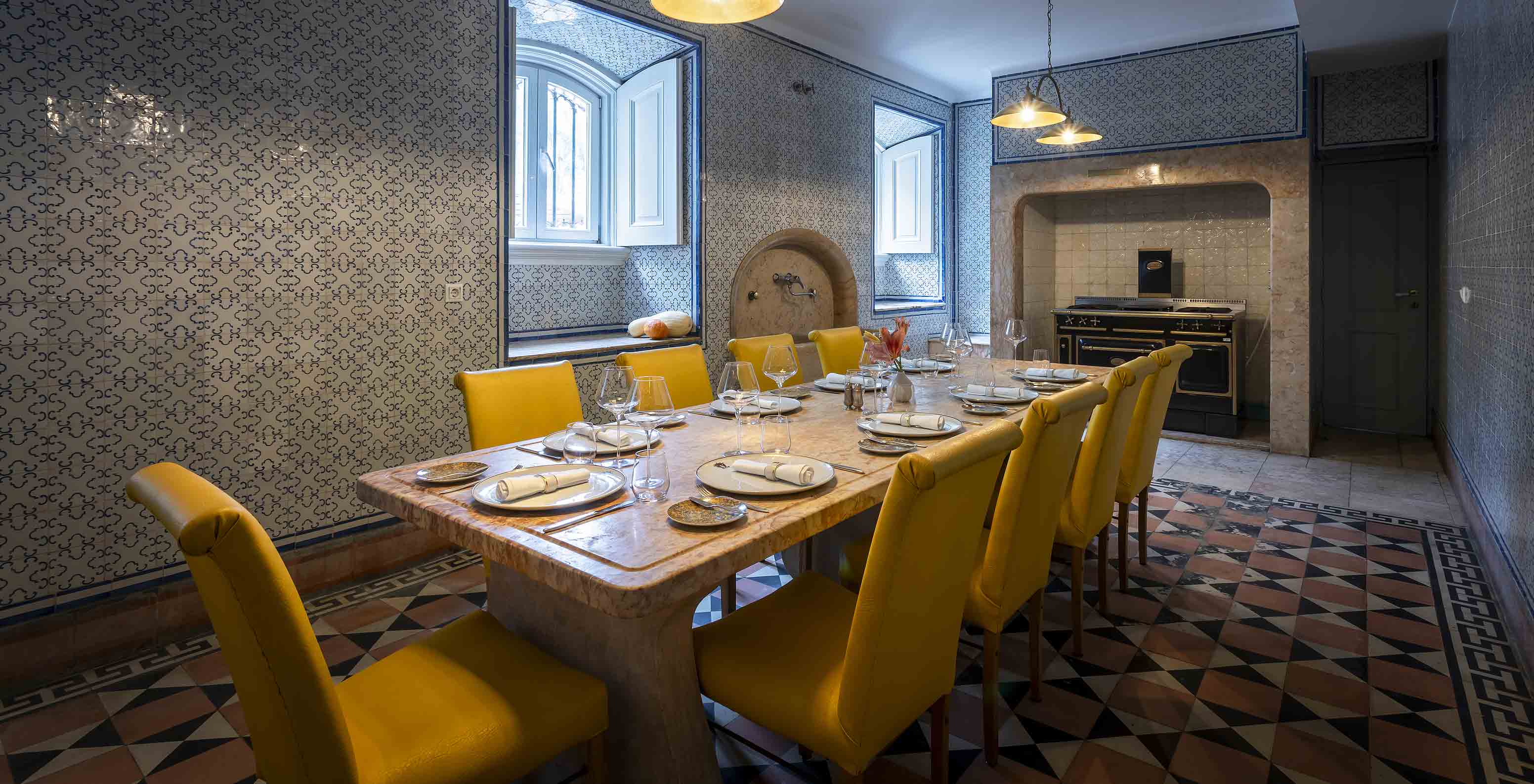 Le Pestana Palace possède une ancienne cuisine pour des événements privés, avec une table en pierre et des chaises jaunes