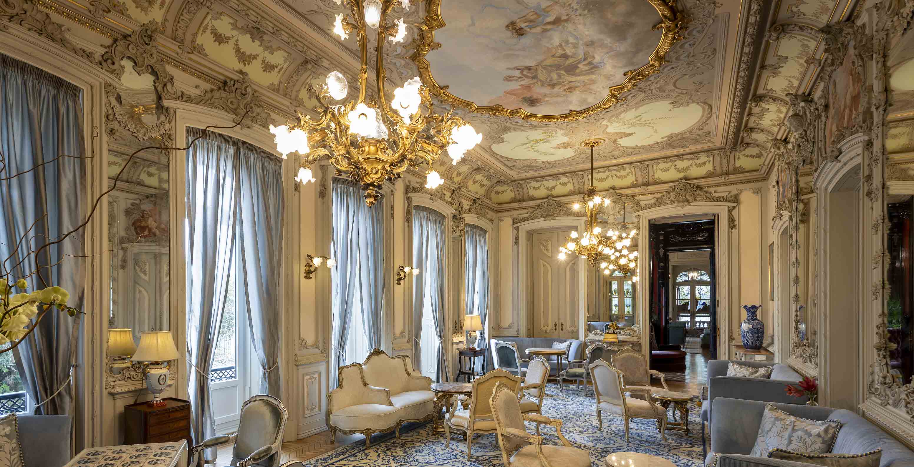 Le Pestana Palace possède un salon dans le palais avec des murs et un plafond ornés, ainsi que des fauteuils et canapés bleus