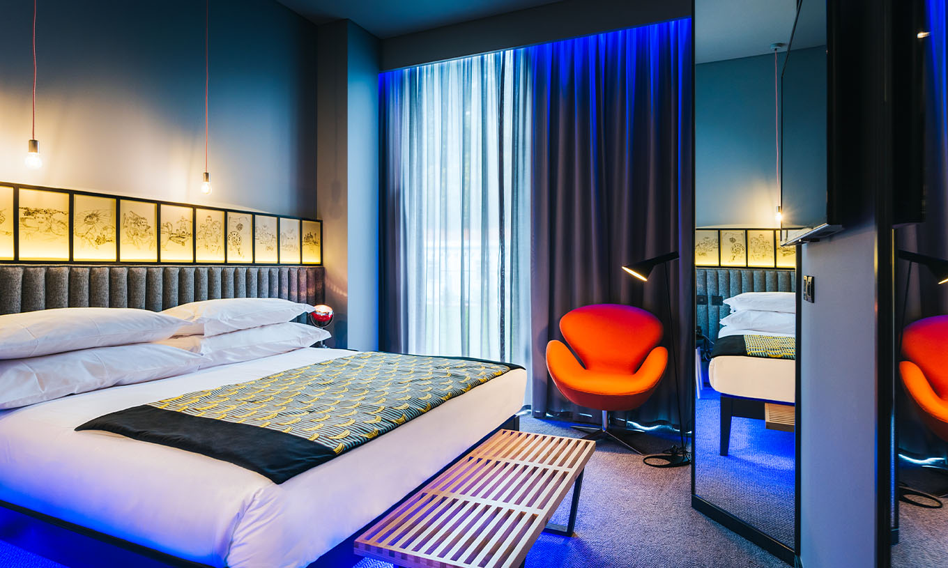 La Chambre CR7 du Pestana CR7 Funchal a un espace spacieux avec un lit double, un banc et une chaise confortable