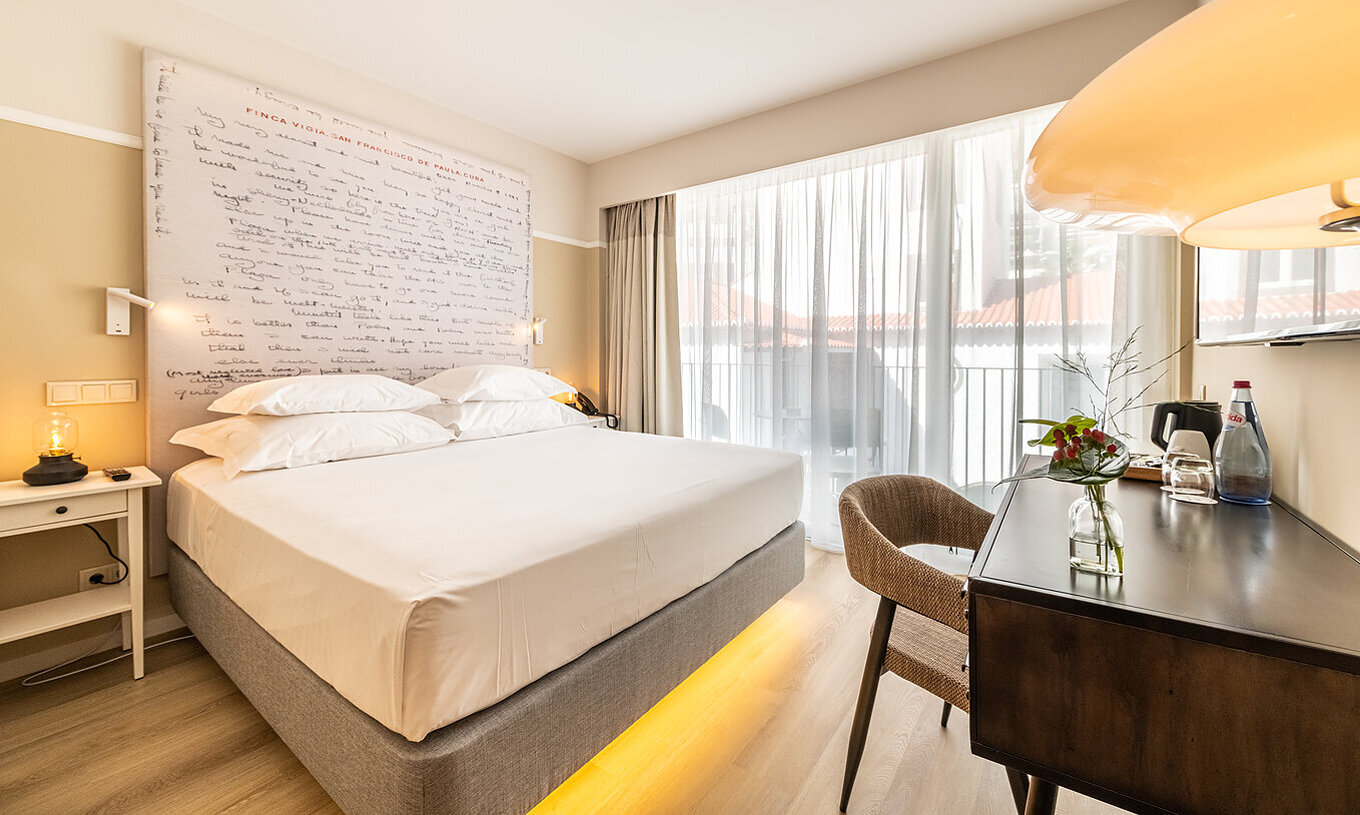 La chambre Supérieure du Pestana Fisherman Village a un lit double avec une tête de lit avec phrases écrites et un balcon