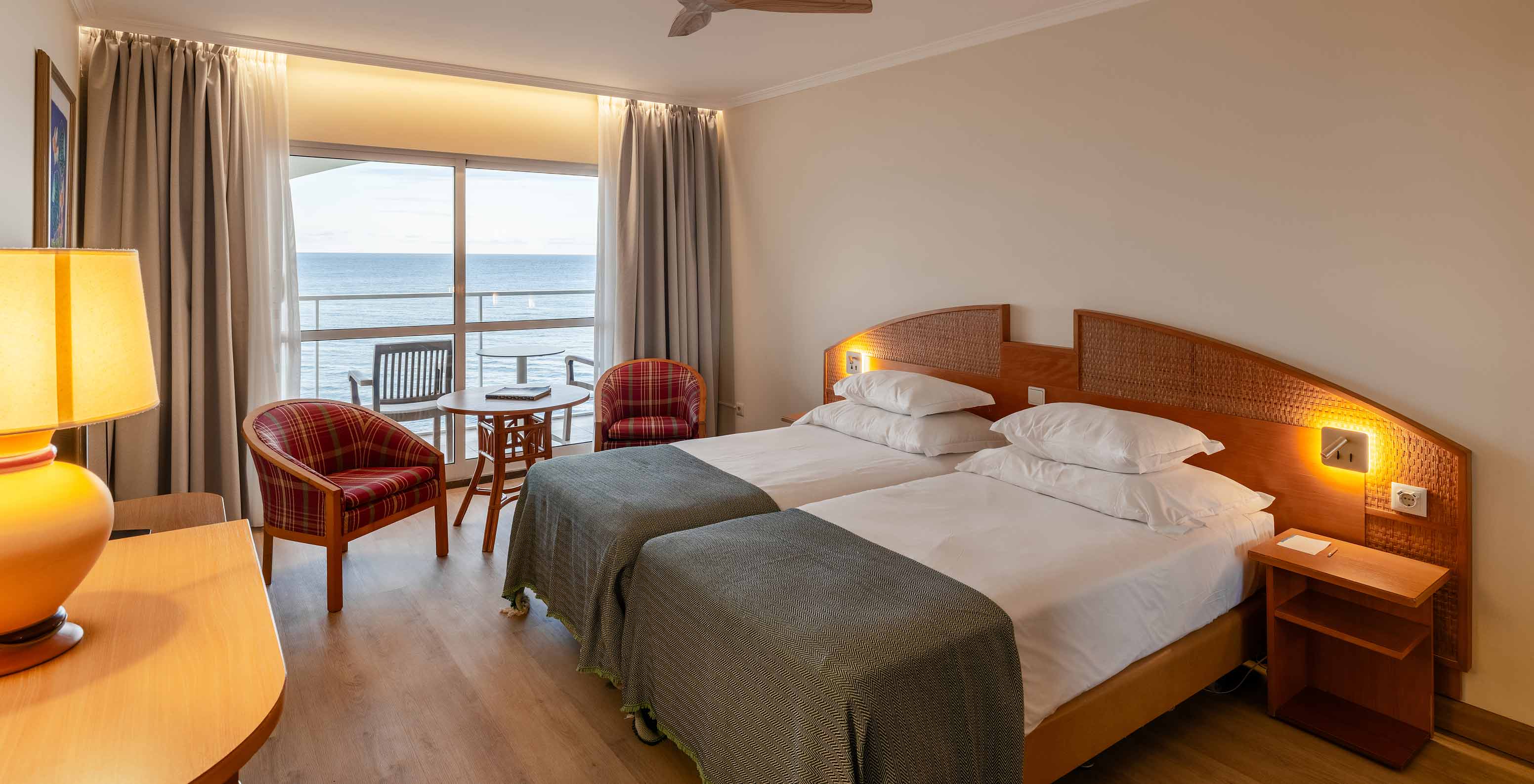 Le Superior Sea View du Pestana Ocean Bay All Inclusive dispose d'un lit double, de deux fauteuils et d'un balcon 