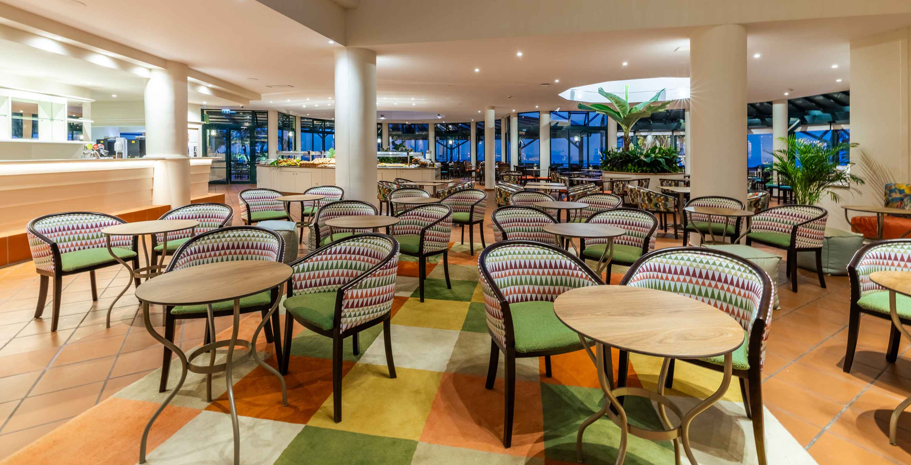 Le bar Arlequim de l'hôtel 5 étoiles à Funchal, à Madère, dispose de chaises avec des tables rondes et une moquette