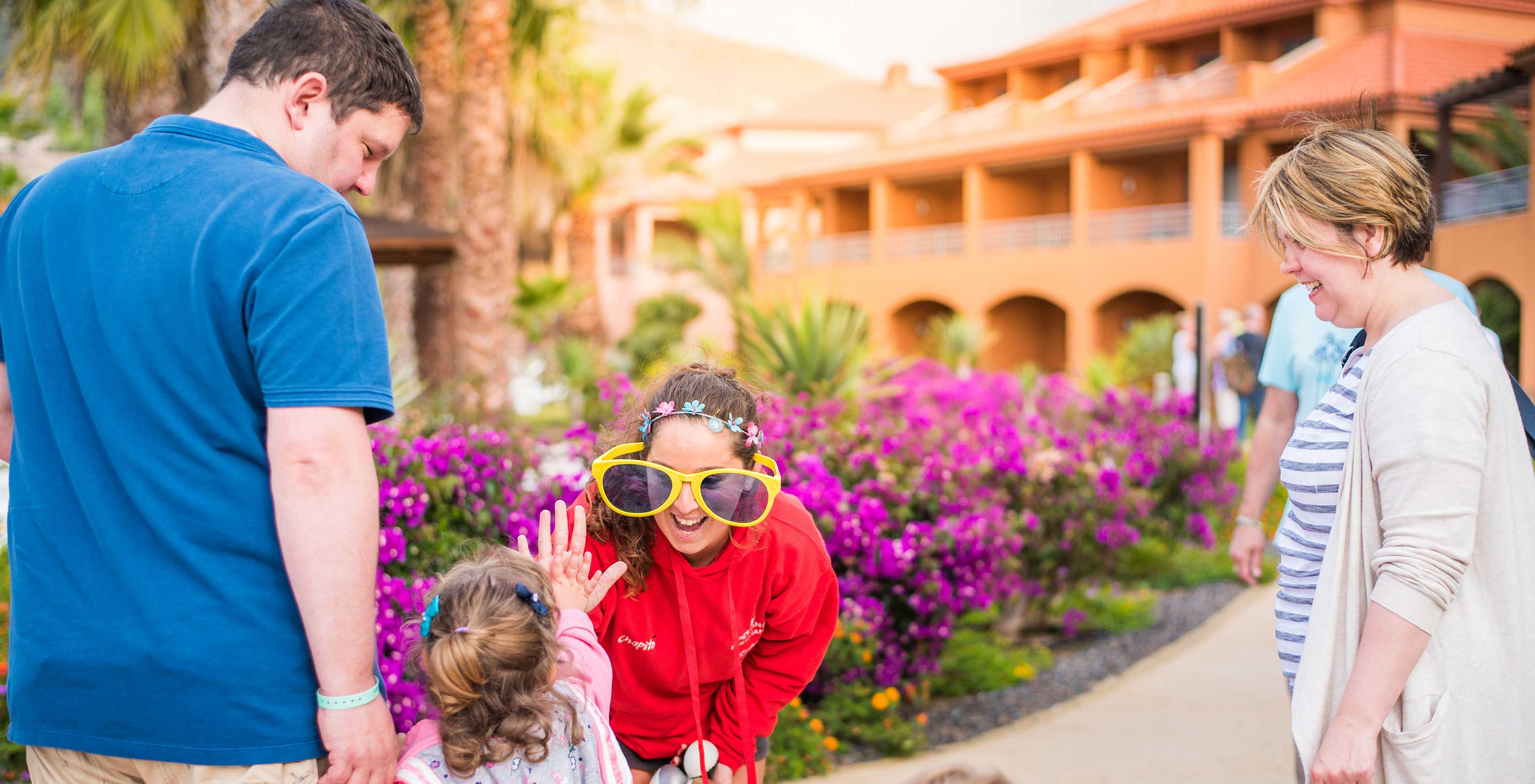 Famille s'amusant Pestana Porto Santo, grandes lunettes soleil, fleurs violettes jour ensoleillé