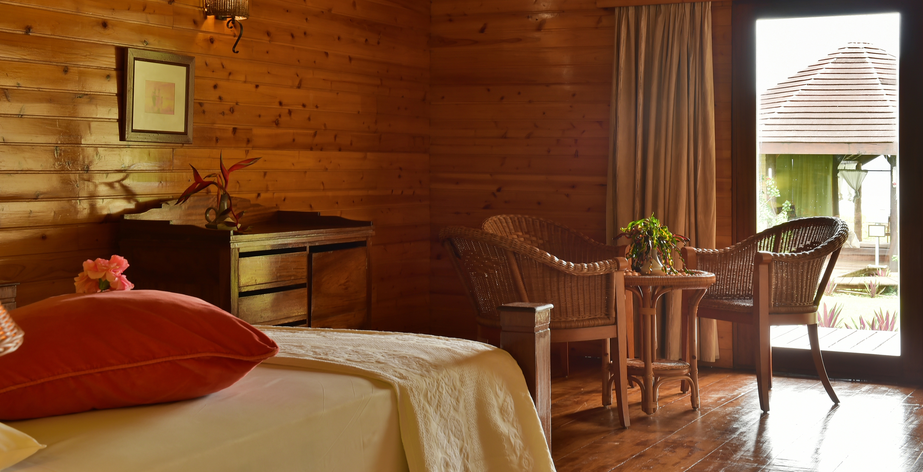 Le Double Supérieur du Pestana Equador Ilheu das Rolas a un lit, une commode en bois et une table avec des chaises en rotin