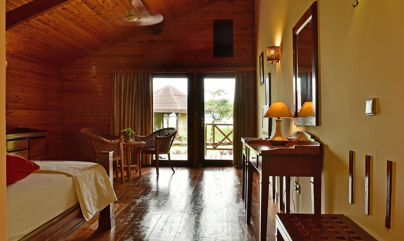 Le Double Supérieur du Pestana Equador Ilheu das Rolas a une commode en bois, un miroir et une fenêtre avec vue sur le jardin