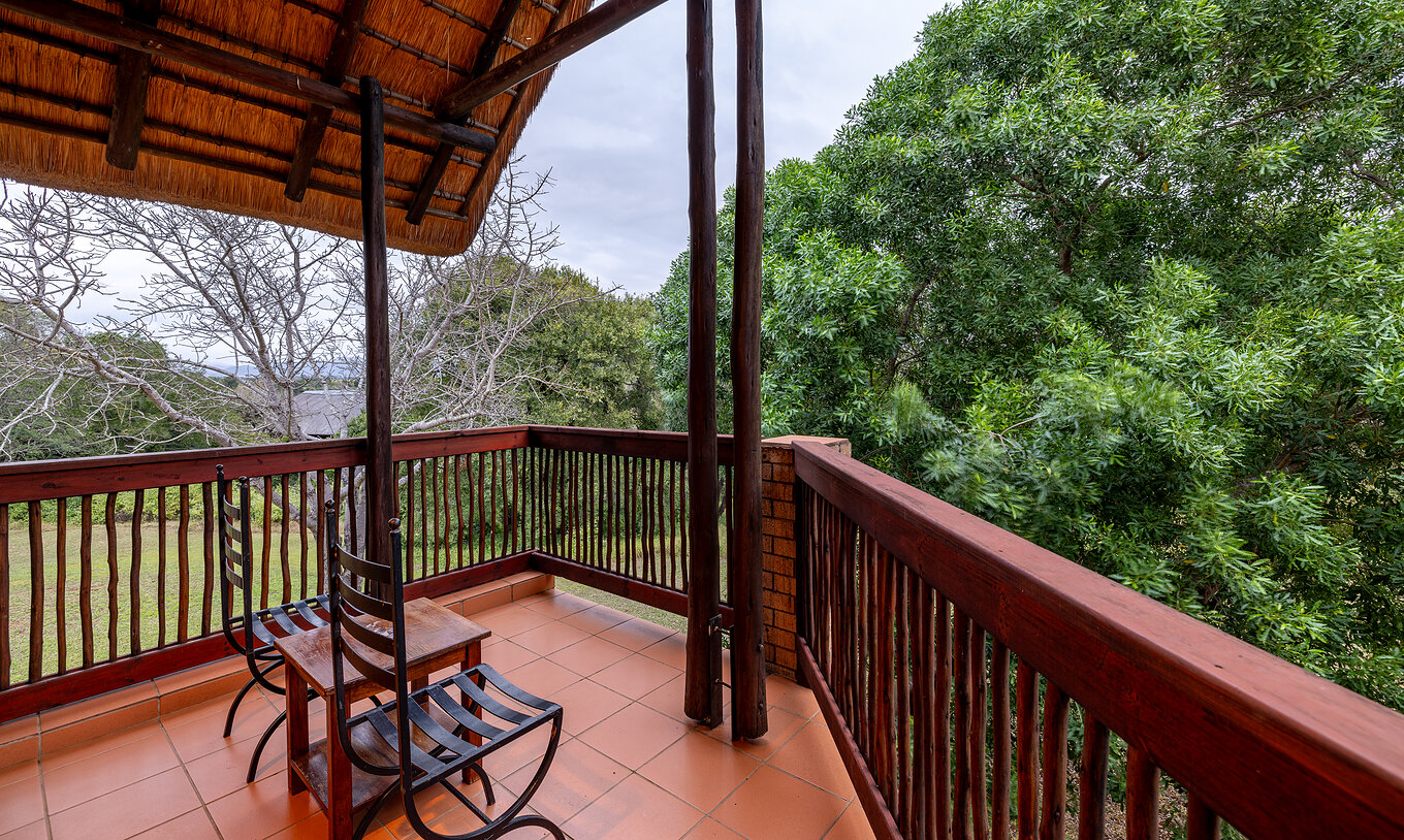 La Chambre Classique du Pestana Kruger Lodge a un balcon avec une balustrade en bois et vue sur le jardin