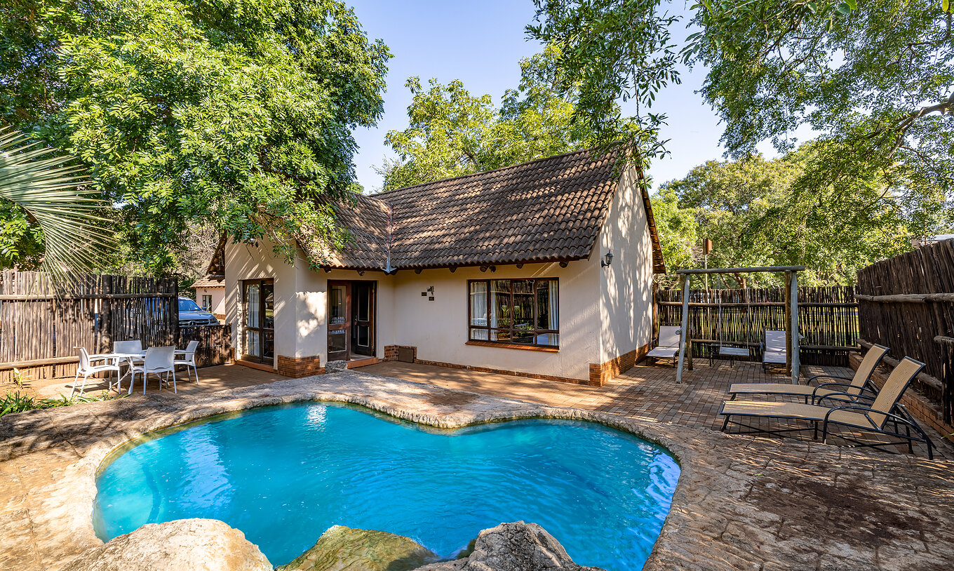Le Rhino Family Cottage du Pestana Kruger Lodge a une piscine privée avec chaises longues près de la chambre