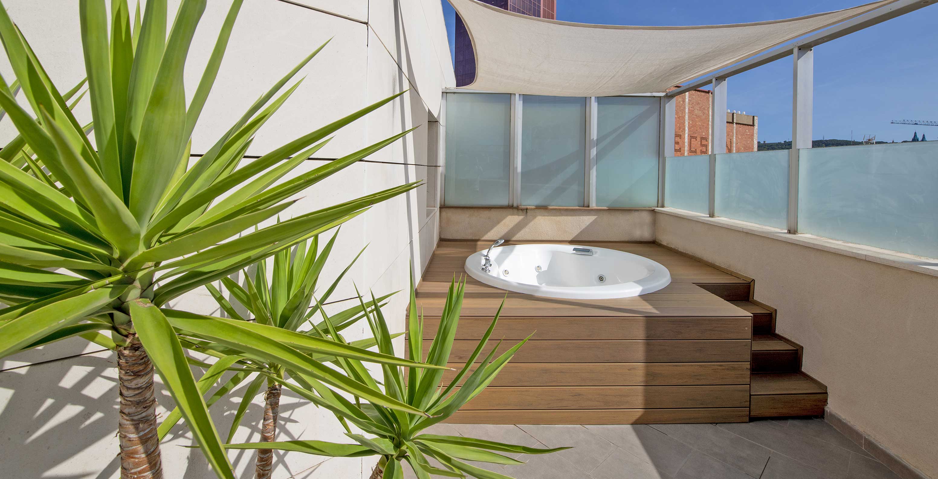 La Junior Suite avec jacuzzi sur la terrasse du Pestana Arena Barcelona dispose d’une terrasse avec jacuzzi, chaises et plantes
