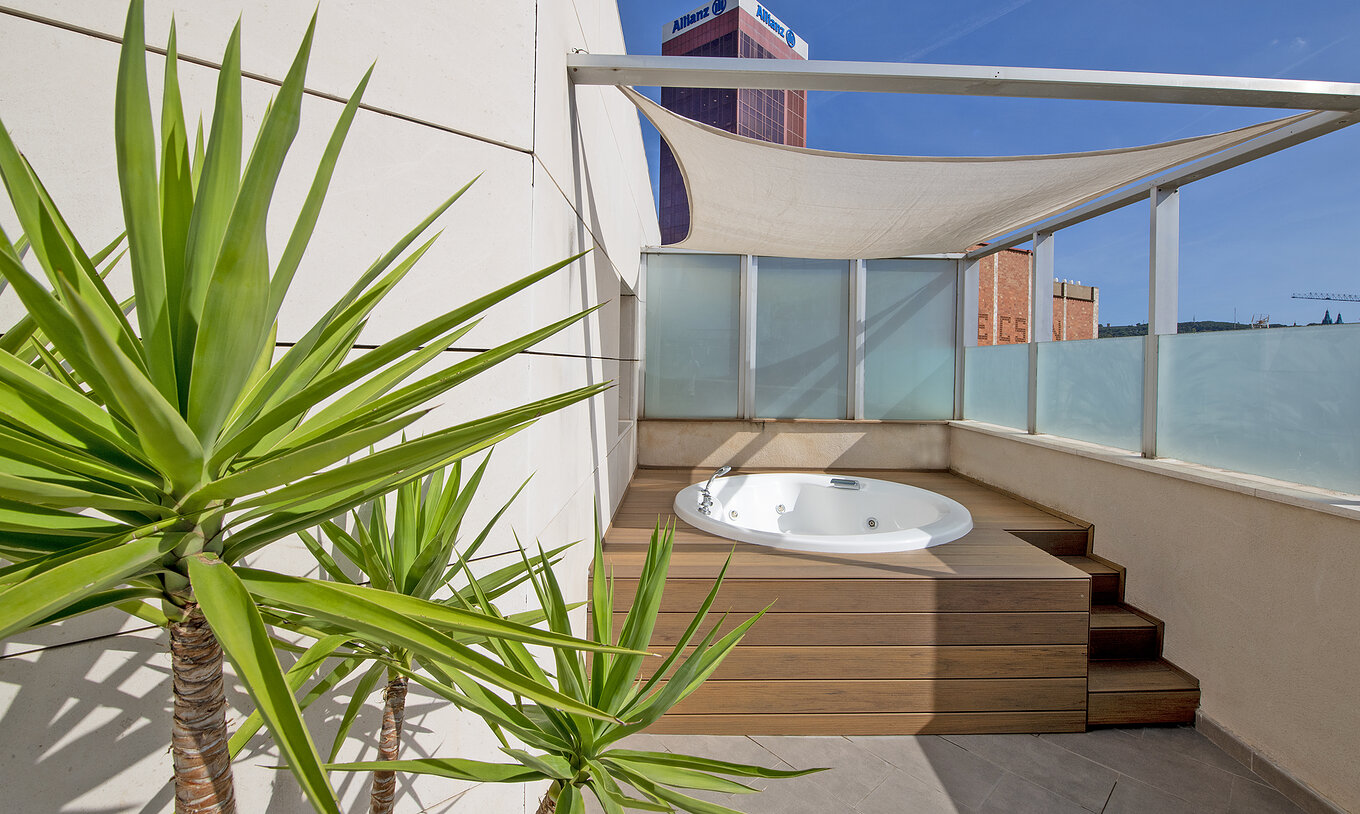 La Junior Suite avec jacuzzi sur la terrasse du Pestana Arena Barcelona dispose d’une terrasse avec jacuzzi, chaises et plantes