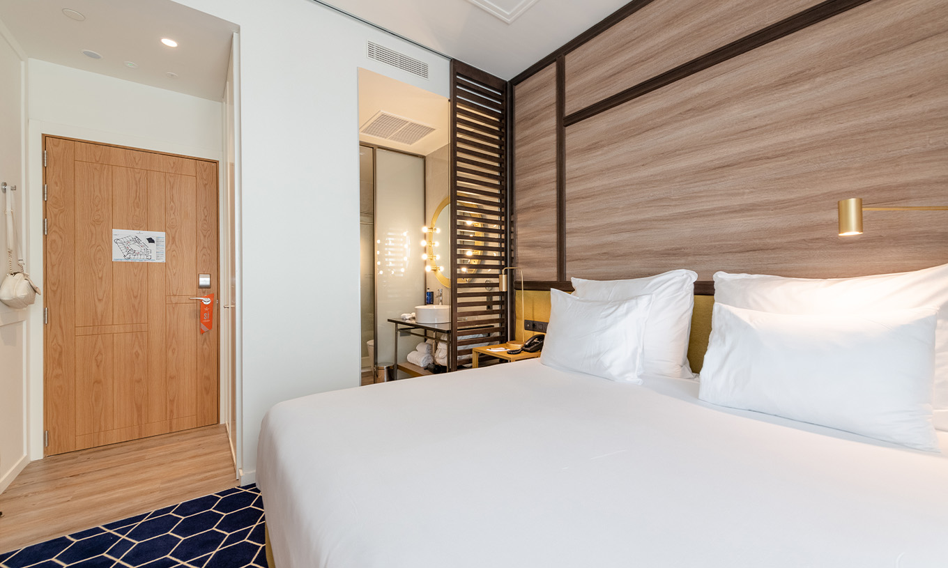 Le Premium Grand avec Balcon et Vue du Pestana CR7 Gran Vía Madrid a un lit double, une séparation et un miroir lumineux