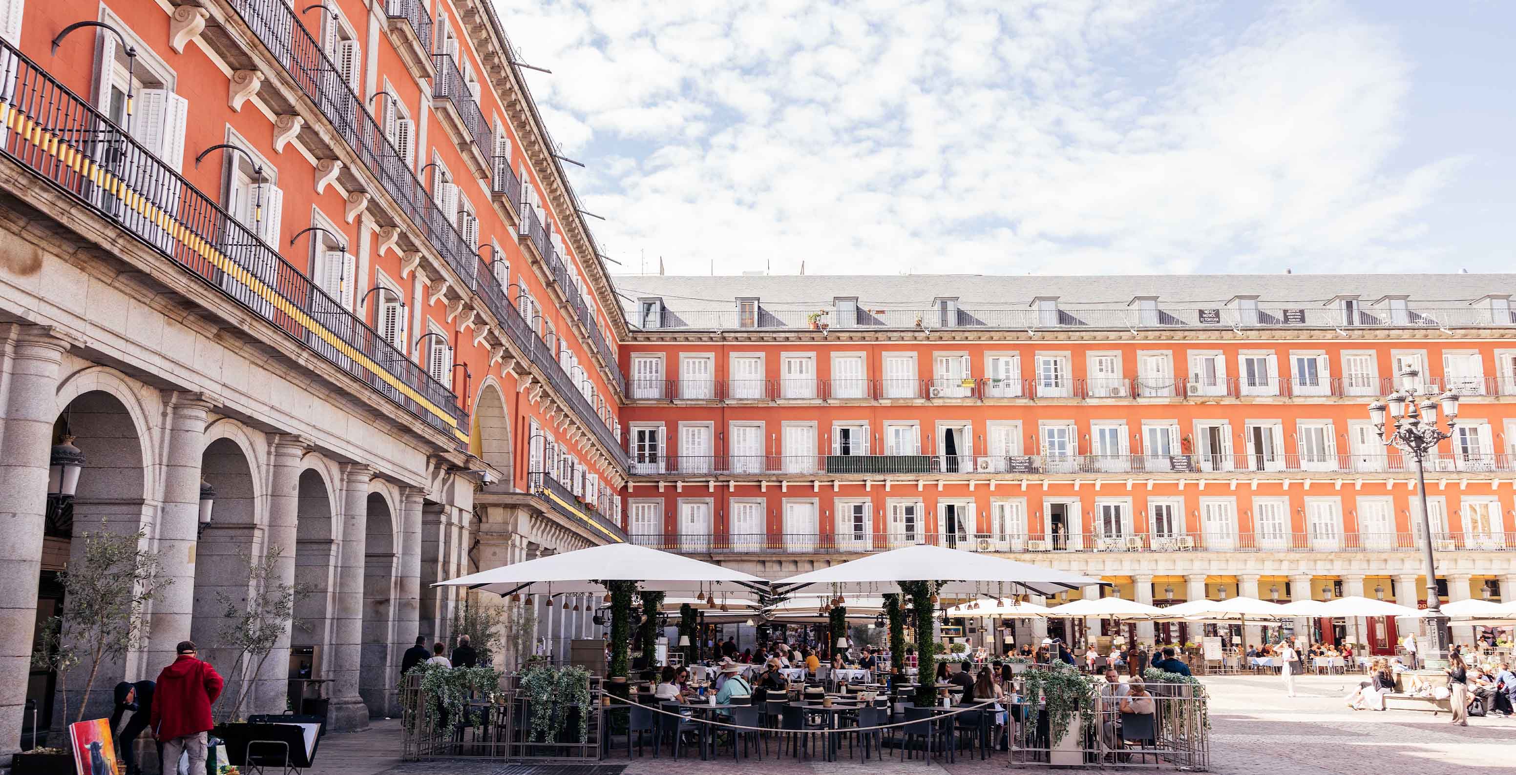 Vue de la terrasse du restaurant du Pestana Collection Plaza Mayor, avec parasols et tables, au centre de la Plaza Mayor
