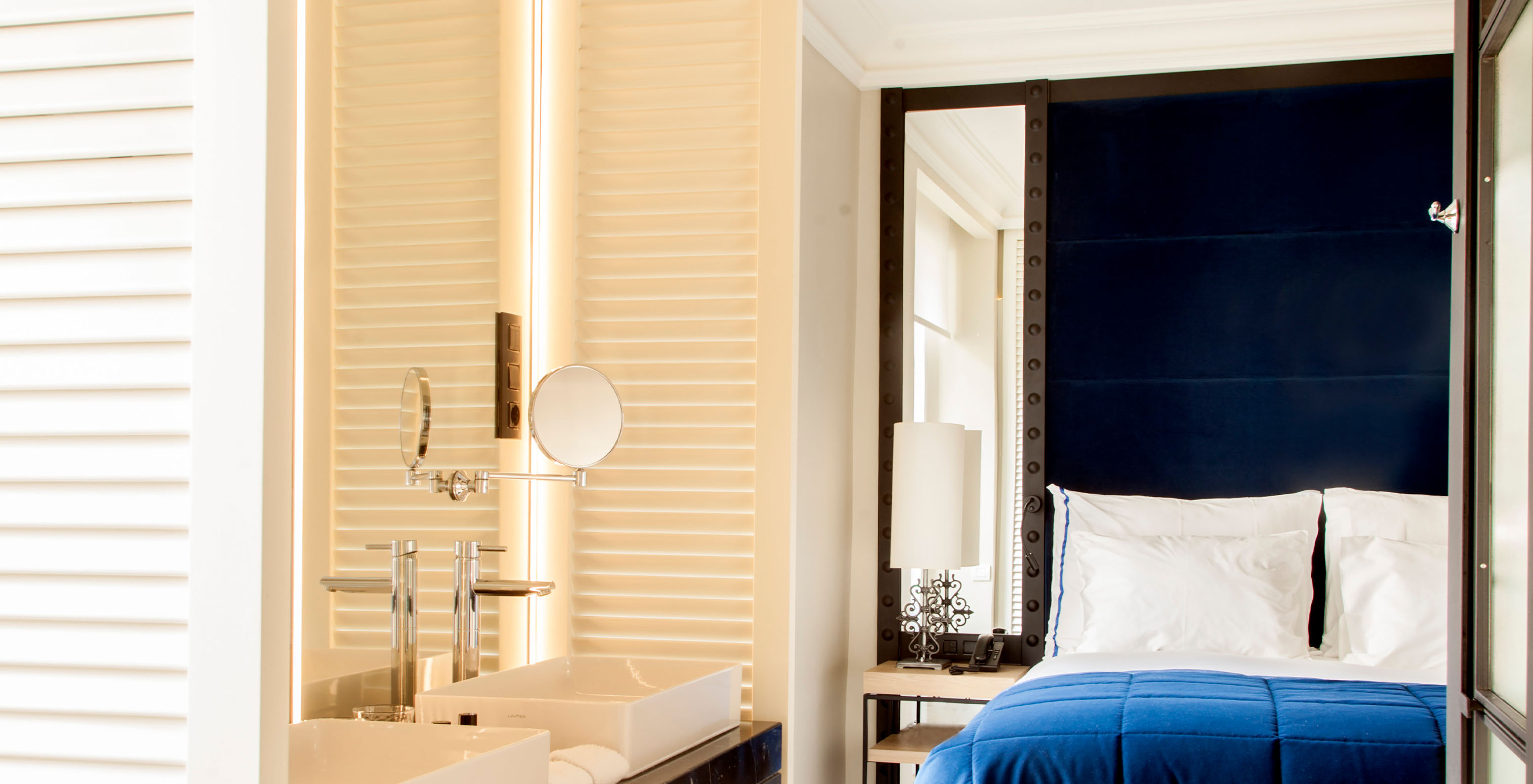La Chambre Supérieure du Pestana Collection Plaza Mayor a un lit double avec tête de lit bleue avec miroir et un lavabo