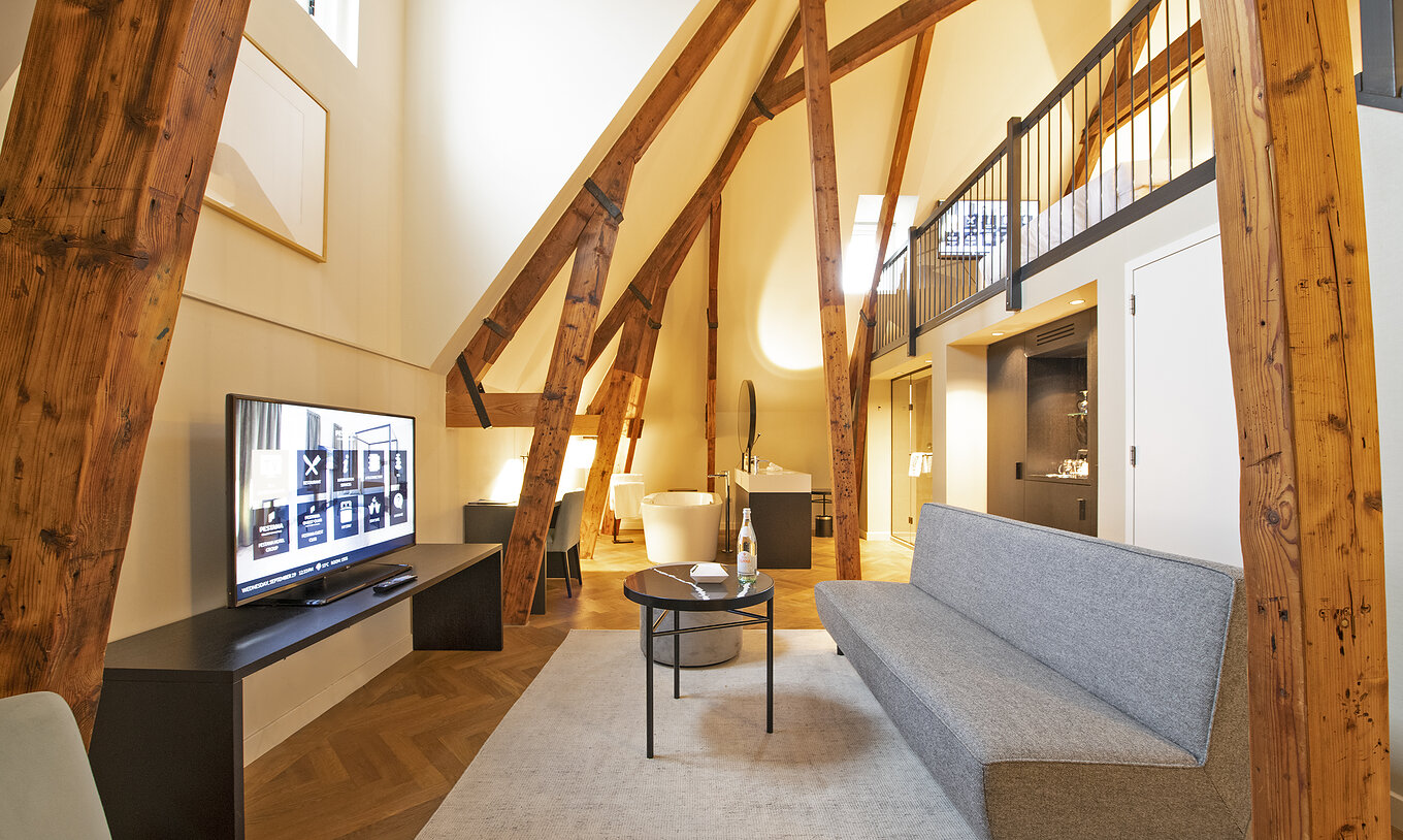 La Clock Tower Suite du Pestana Amsterdam Riverside a un salon avec canapé, table basse, et télévision