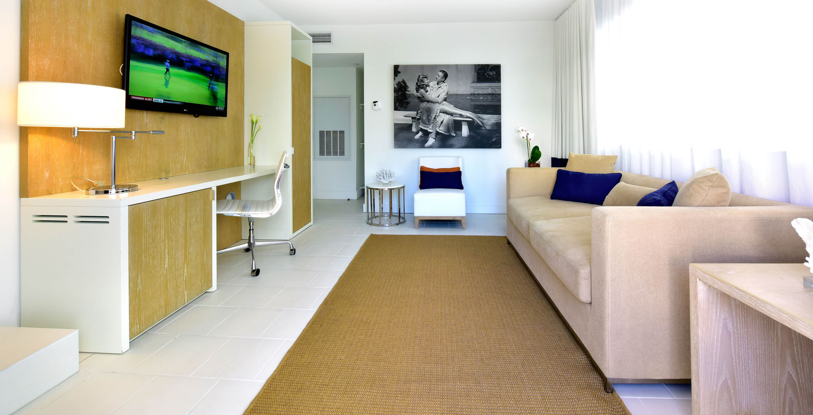 La Suite à deux chambres avec balcon du Pestana Miami South Beach a salon avec canapé, chaise, télévision et un bureau
