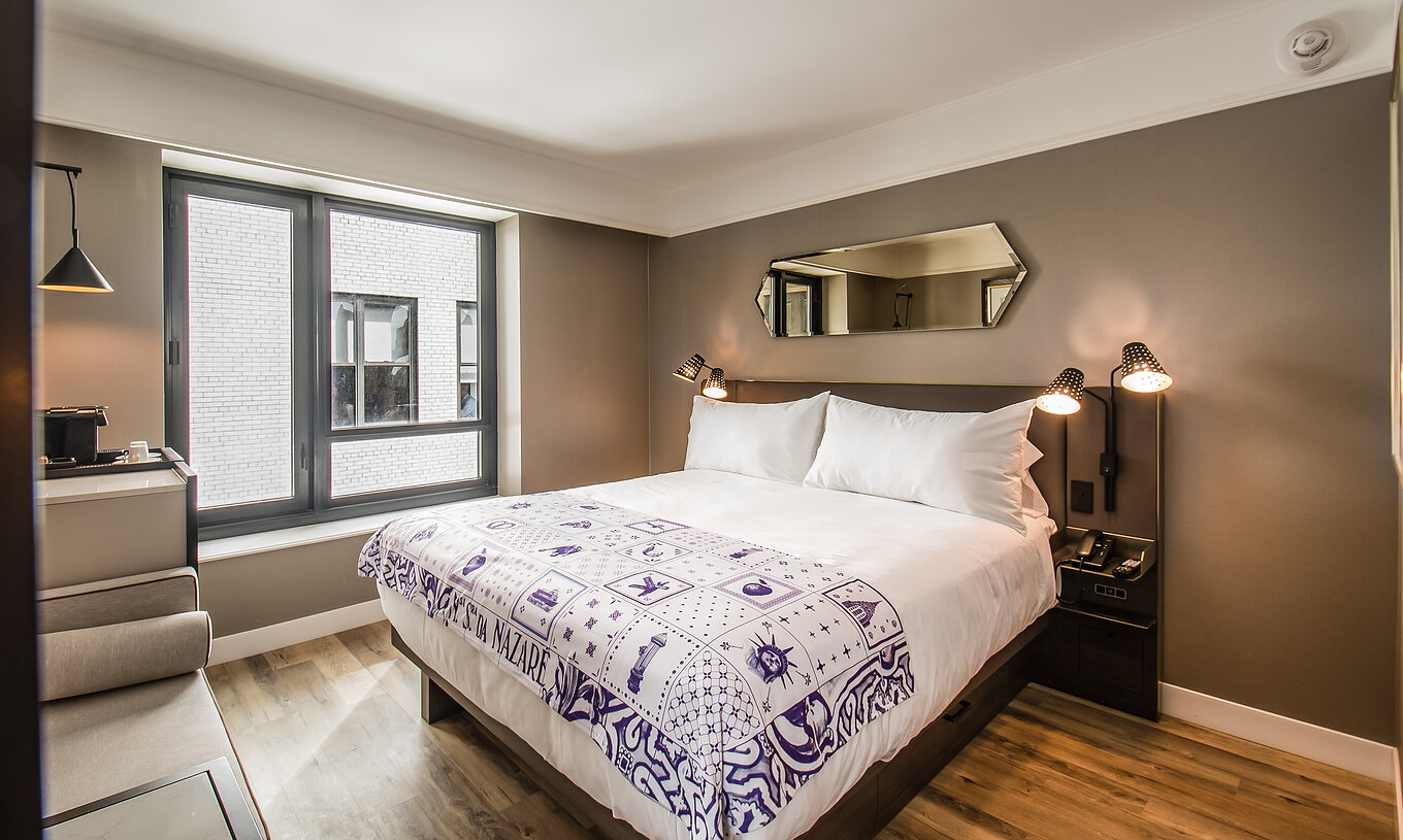 La chambre Classique - ADA du Pestana Park Avenue a un lit double, une table de nuit avec lampe et téléphone