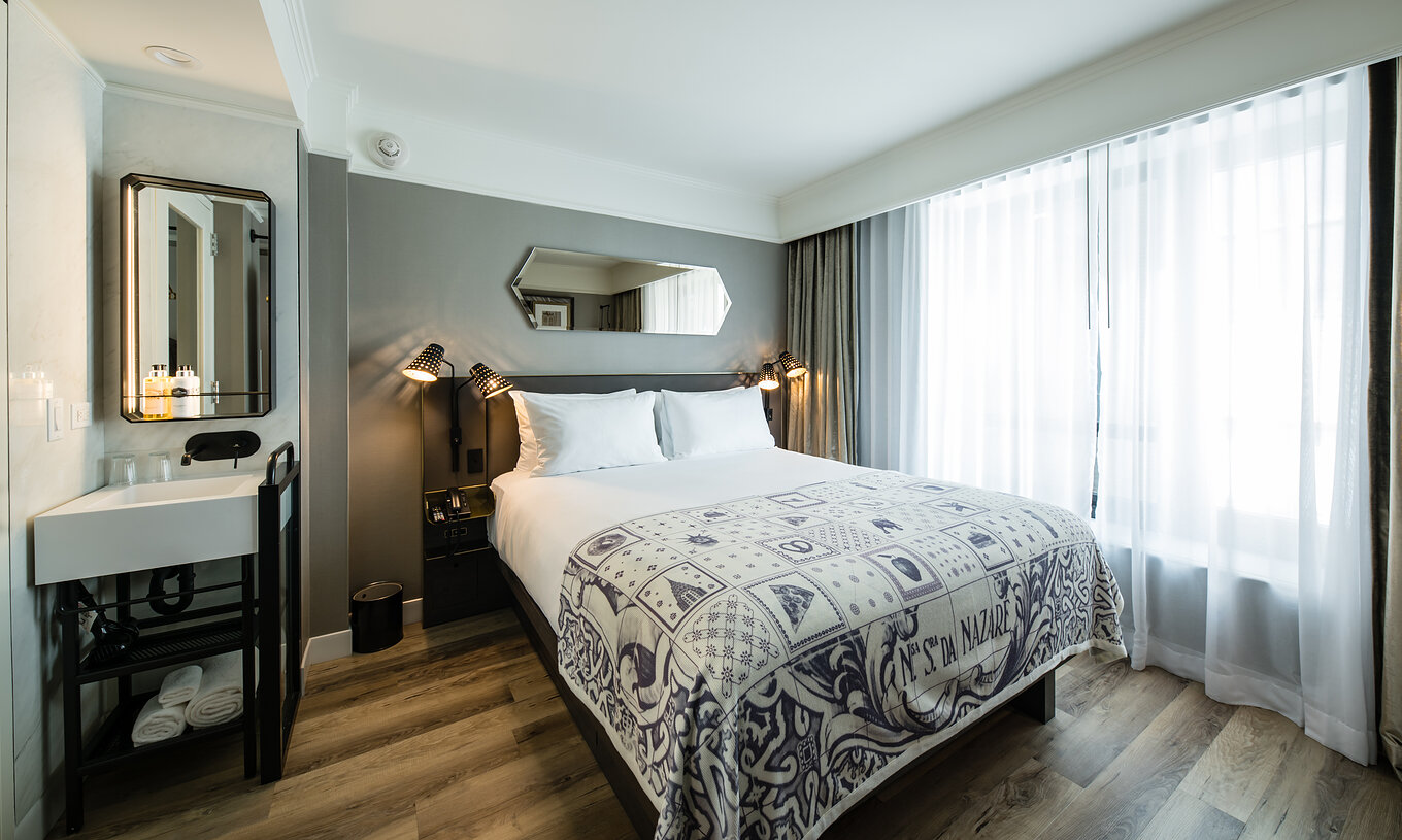 La chambre Supérieure du Pestana Park Avenue a un lit double, lavabo et miroir dans la chambre, et table de nuit