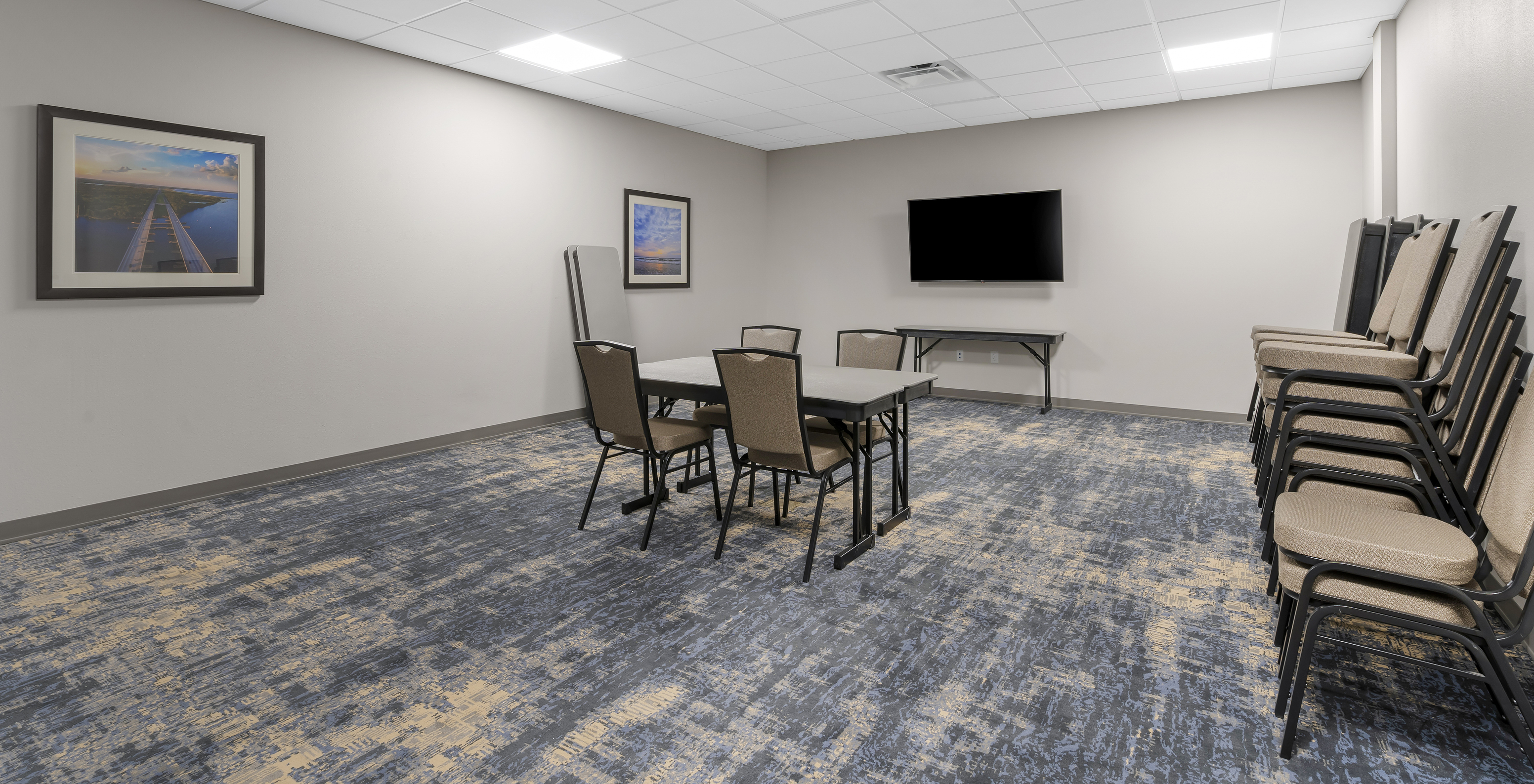 Le Pestana Orlando hôtel avec piscine près de Disney dispose d'une salle de réunion avec table chaises et télévision