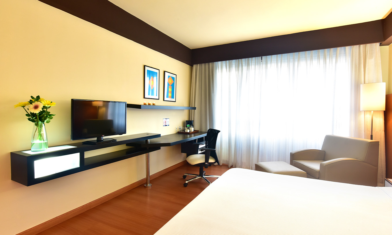 Le Twin Superior du Pestana Caracas a une télévision au fond du lit, une poltrona, un bureau et une fenêtre