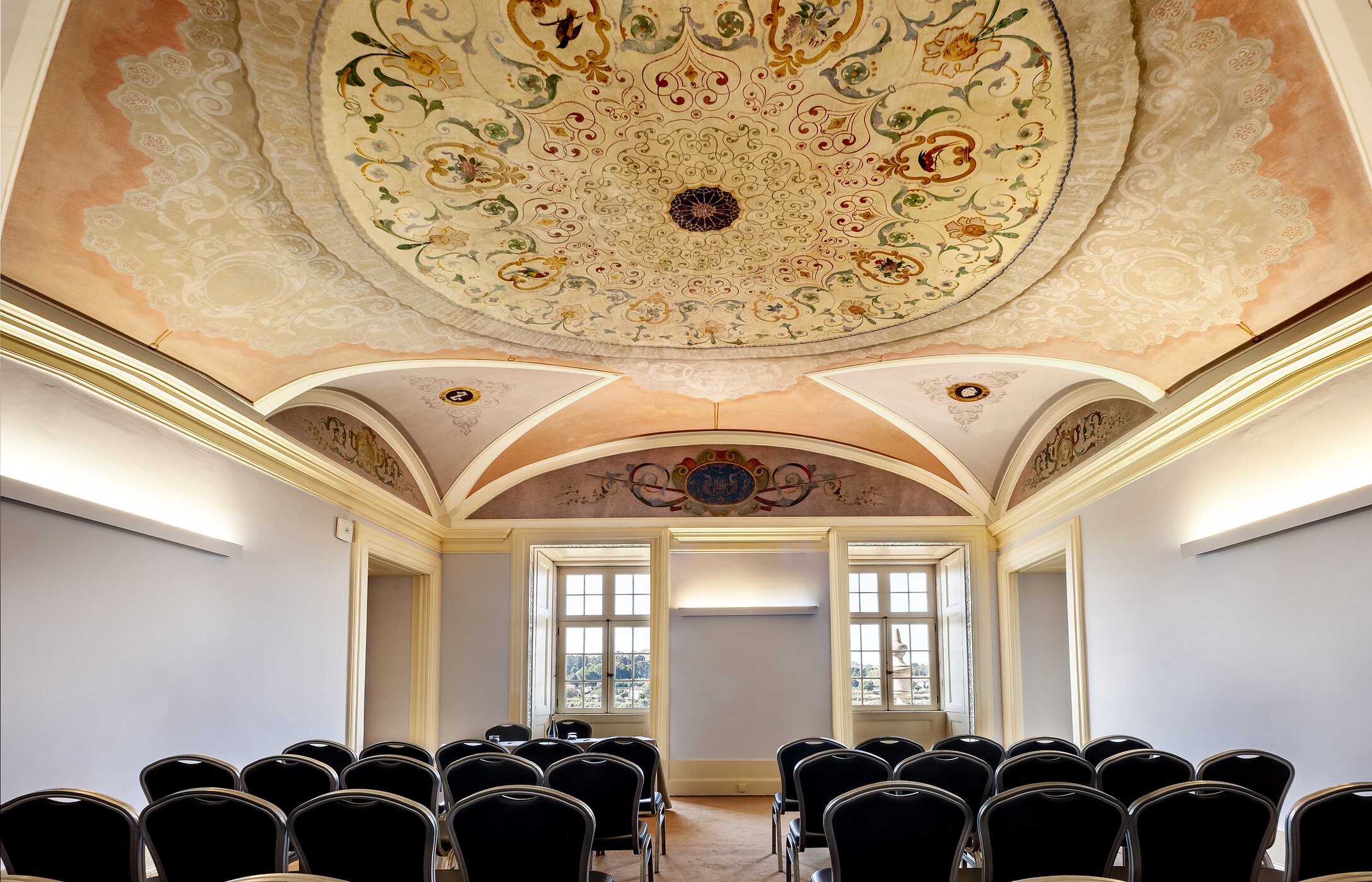 Salle de réunion ou de conférence, avec plafond avec détails chaises et grandes fenêtres laissant entrer la lumière naturelle