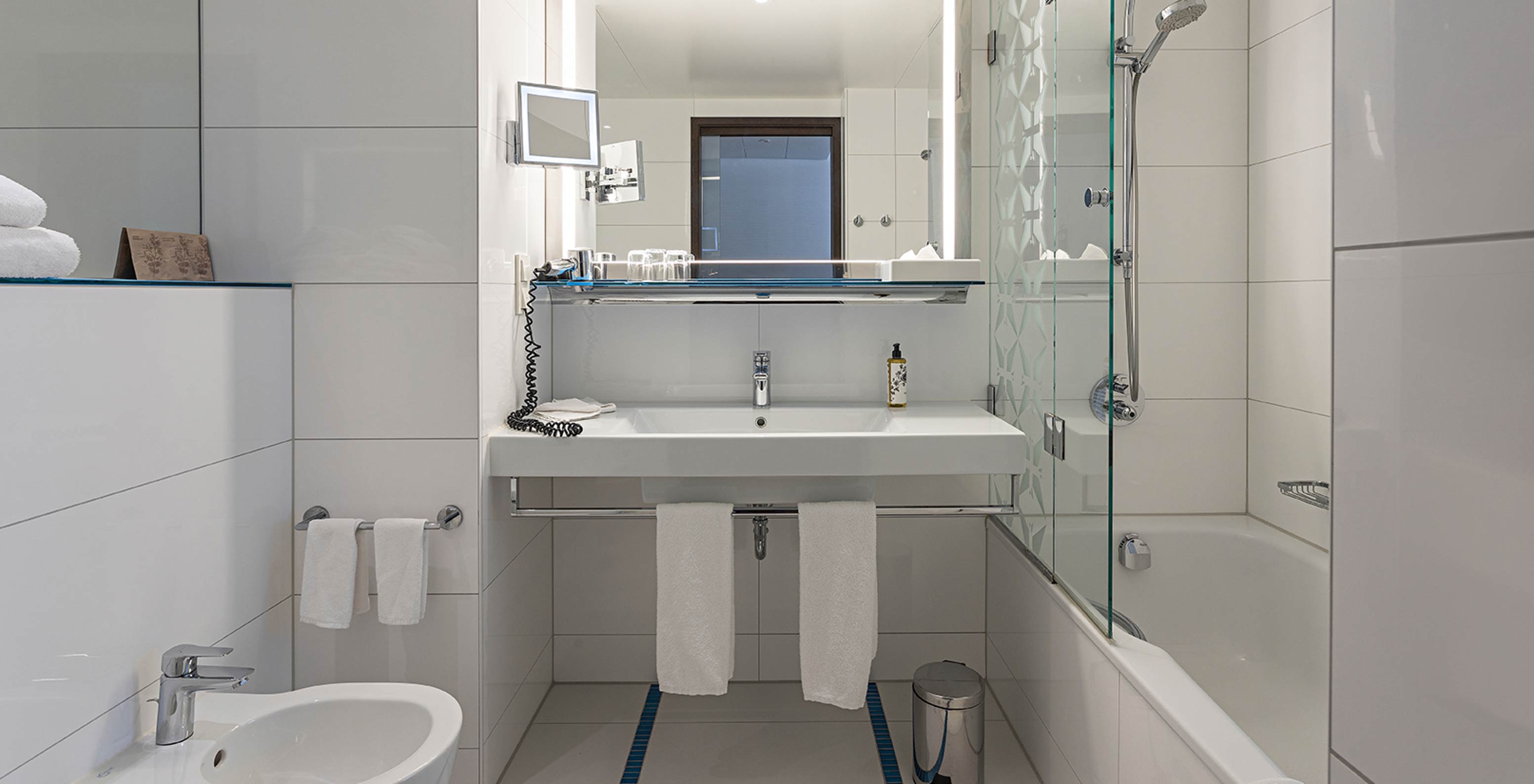 Family Deluxe met badkamer met bad, douche, wastafel en spiegel