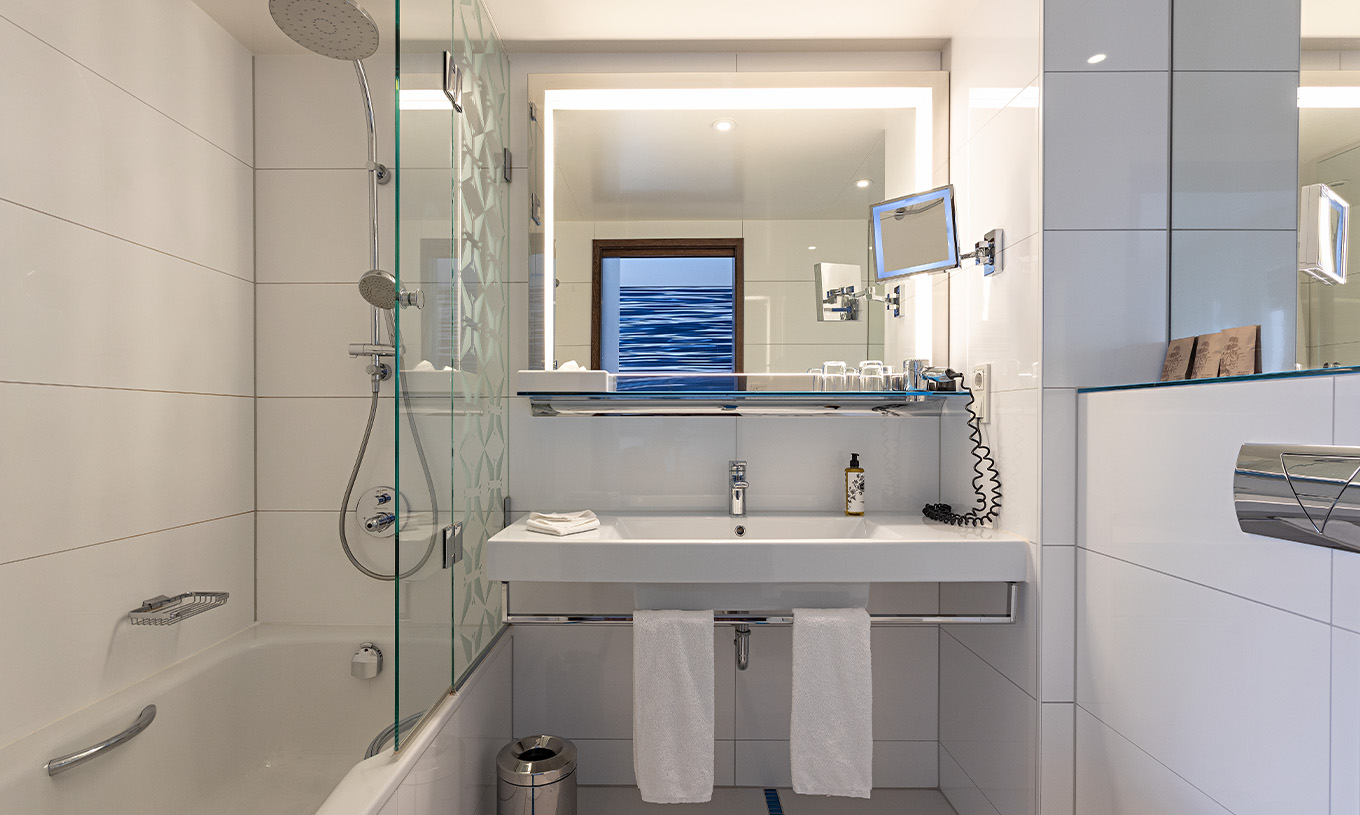 De Premium Kamer met Balkon van Pestana Berlin Tiergarten heeft badkamer met douche, wastafel en spiegel