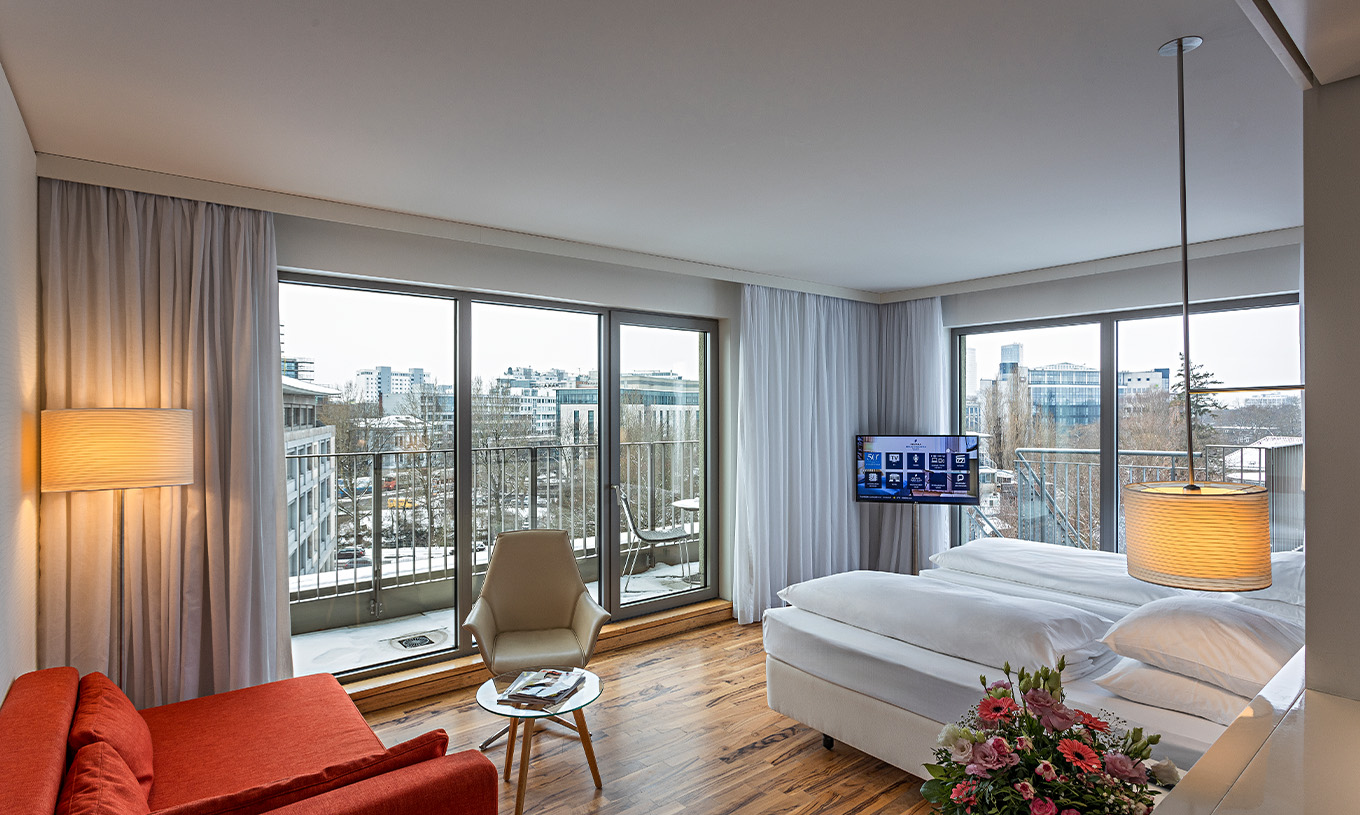 De Premium Kamer met Panoramisch Balkon van Pestana Berlin Tiergarten heeft bank met lamp, televisie en bed