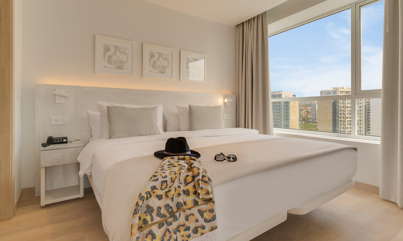 De Premium Suite van Pestana Tanger City Center heeft een tweepersoonsbed met stenen hoofdeinde en een raam met uitzicht
