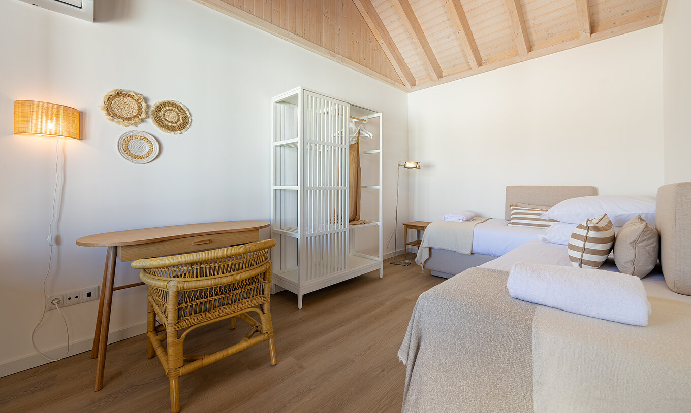 De Standaard Villa bij Pestana Comporta Village Residences heeft een slaapkamer met een bed, een tafel en een rieten stoel