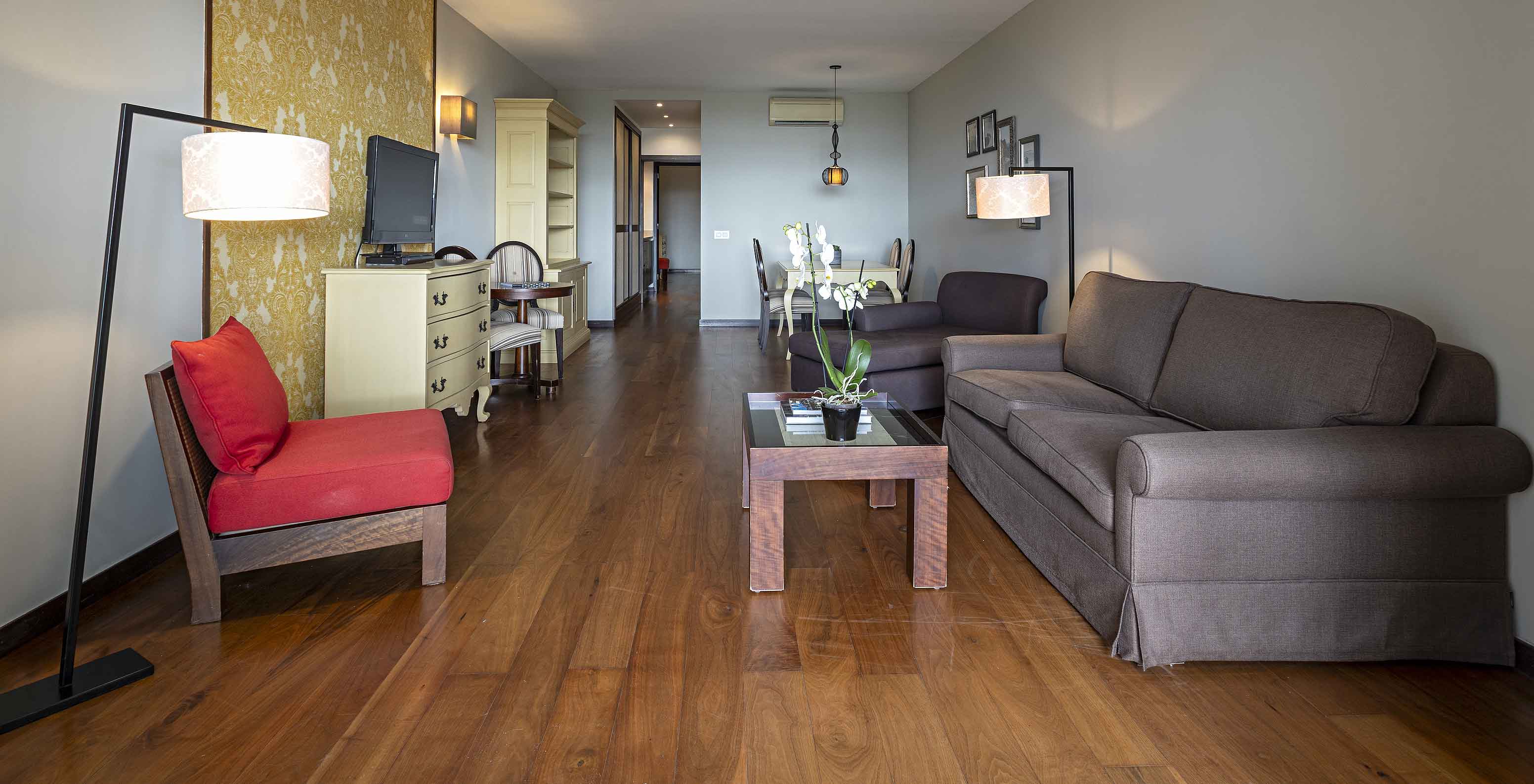 De Cliff Suite T2 in Pestana Alvor Praia heeft een woonkamer met twee banken, behang, een televisie en een tafel