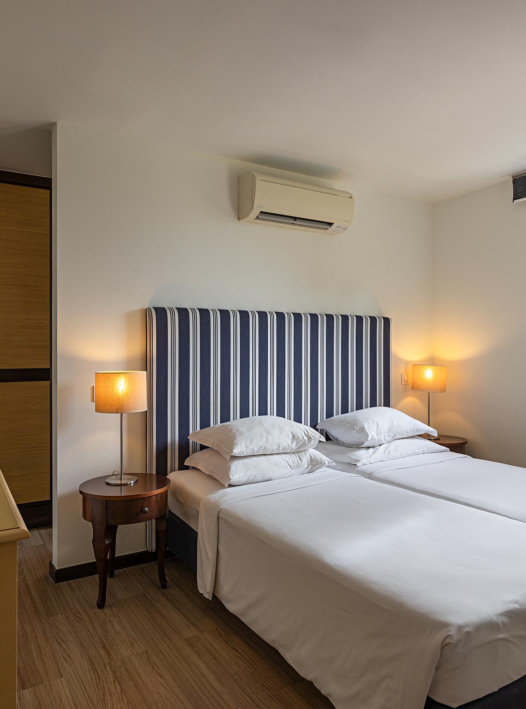 De Cliff Suite T2 in Pestana Alvor Praia heeft een slaapkamer met een bed, een televisie, een kledingkast en airconditioning