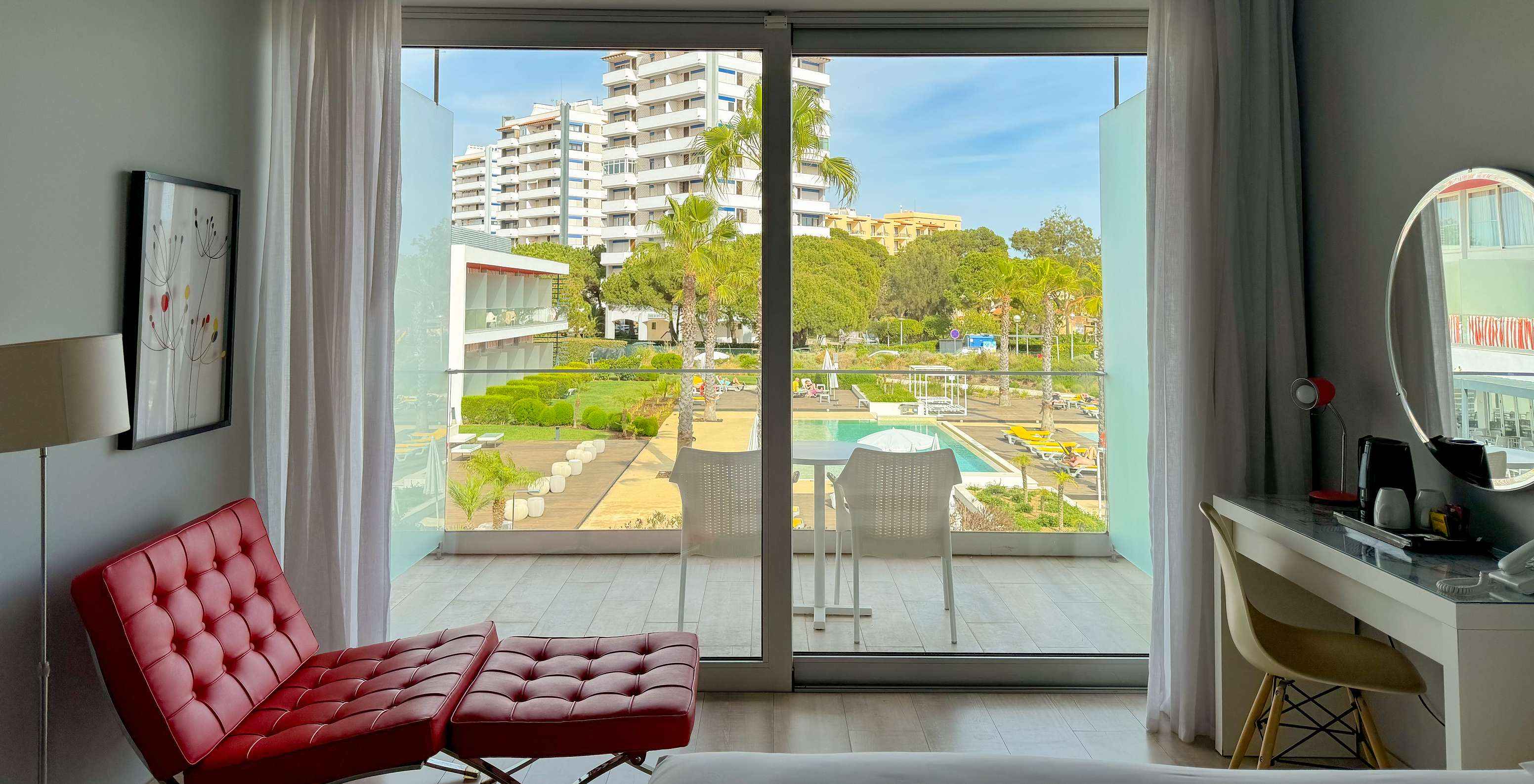 De Superior Deluxe met uitzicht op het zwembad van Pestana Alvor South Beach heeft balkon met tafel en stoelen en uitzicht