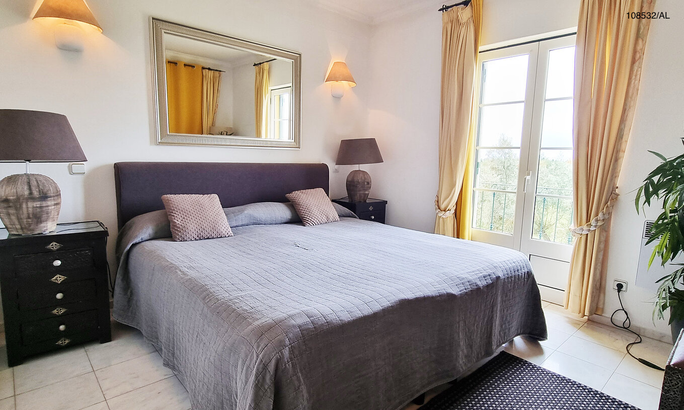 Het appartement Pestana Carvoeiro Golf T1 Superior heeft een tweepersoonsbed met twee nachtkastjes en een spiegel