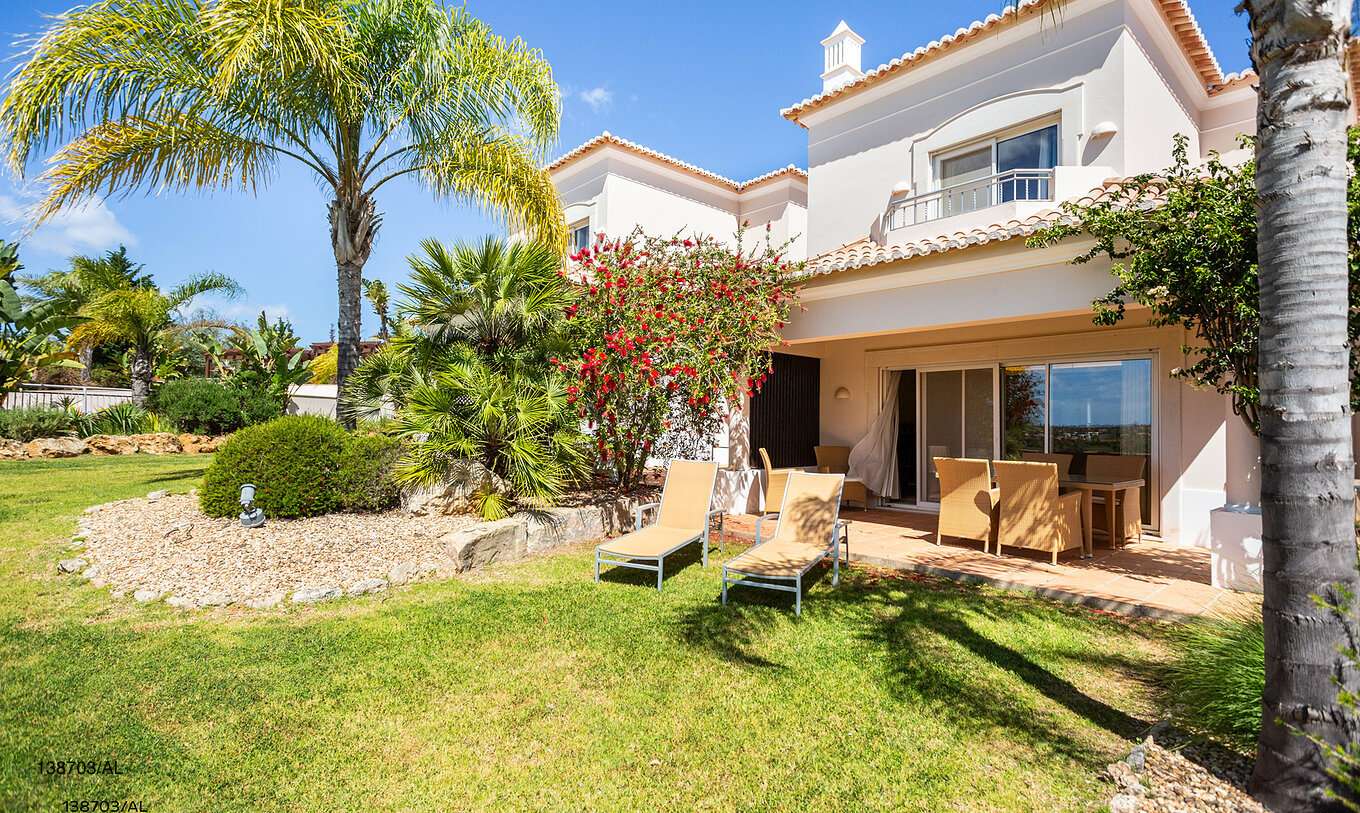 Het appartement Pestana Carvoeiro Golf T2 Superior heeft een buitenruimte met een gazon en gele ligstoelen