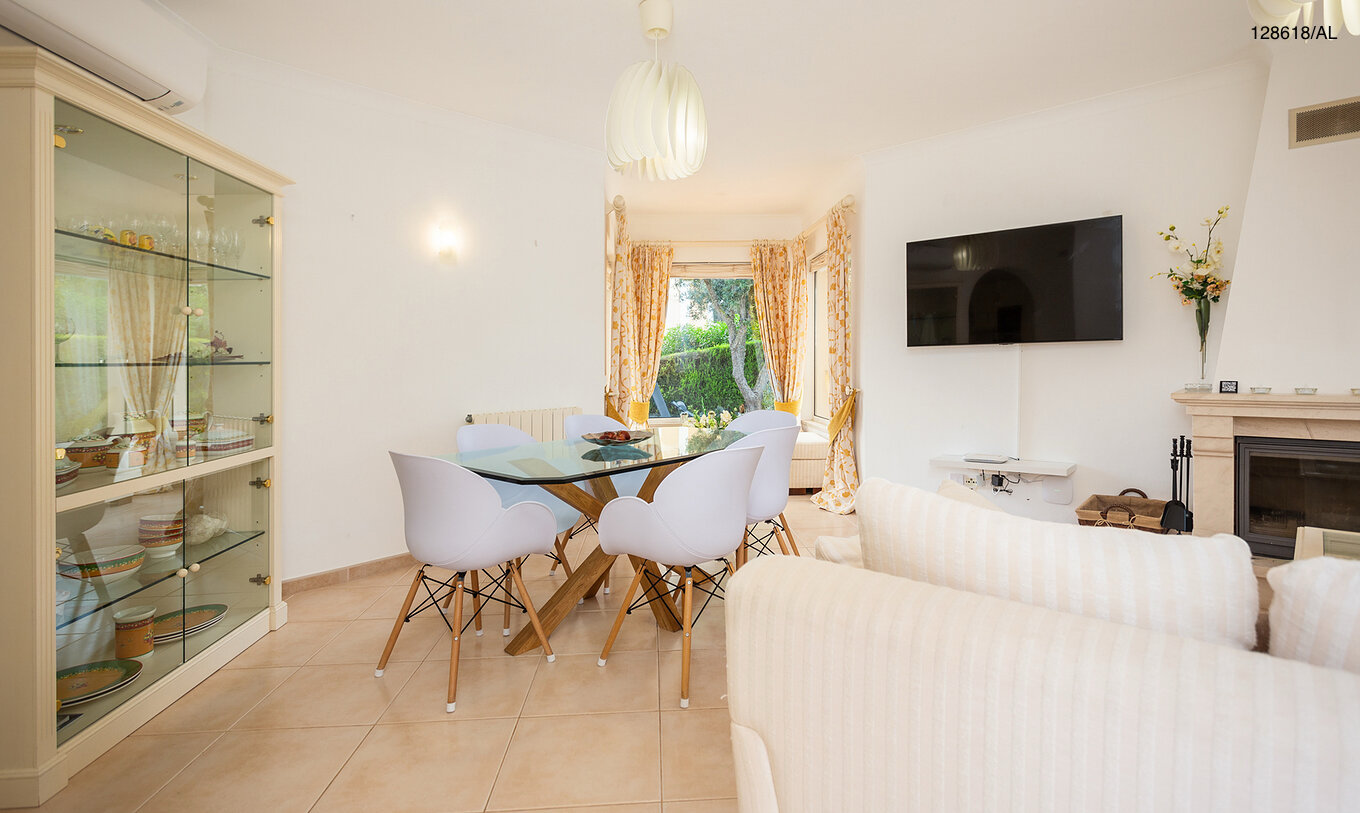 De villa Pestana Carvoeiro Golf V3 Superior heeft een woonkamer met een tafel van glas, stoelen en een televisie