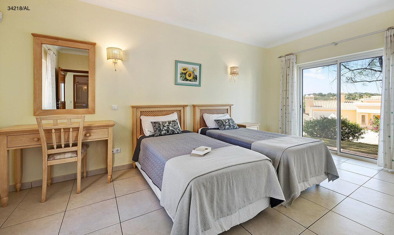 De villa Pestana Carvoeiro Golf V4 Standard heeft een slaapkamer met twee eenpersoonsbedden, een spiegel en een tafel
