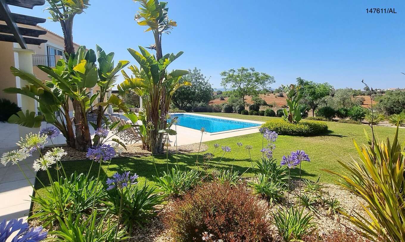 De villa Pestana Carvoeiro Golf V5 Superior heeft een buitenruimte met een zwembad, een gazon en bomen eromheen