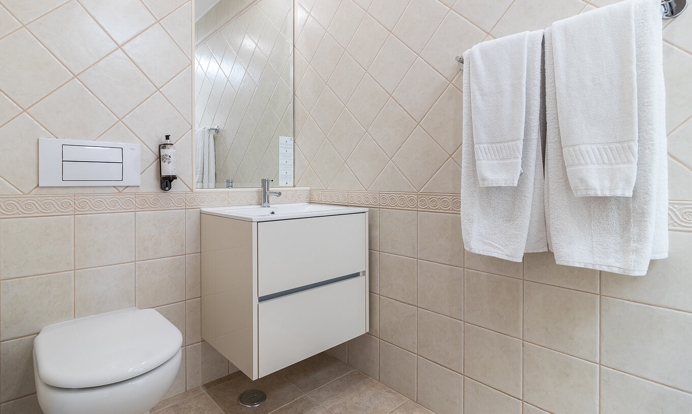 Het tweeslaapkamerappartement bij Pestana Gramacho heeft een elegante badkamer met witte handdoeken en zacht licht