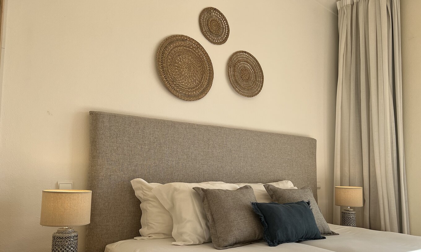 Het Appartement T1 Standard van Pestana Palm Gardens heeft een tweepersoonsbed met decoratieve kussens en schilderijen