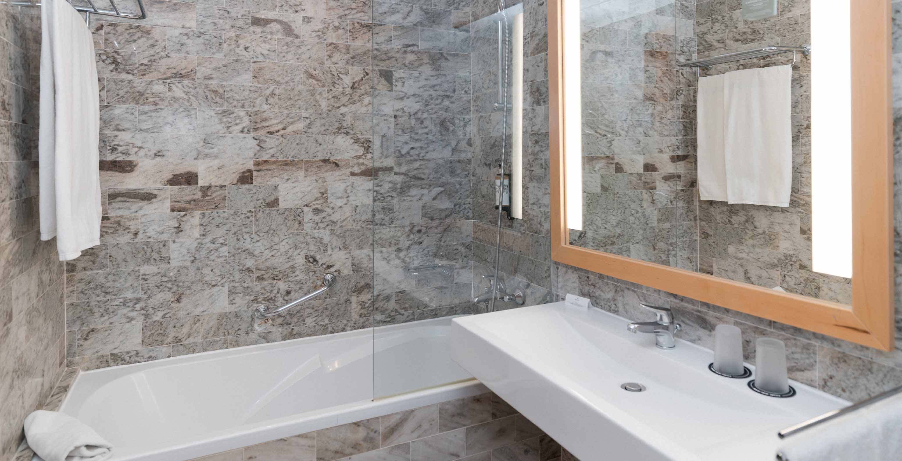 De Superior Suite Zeezicht van Pestana Viking heeft een badkamer met wastafel, grote spiegel en bad met douche