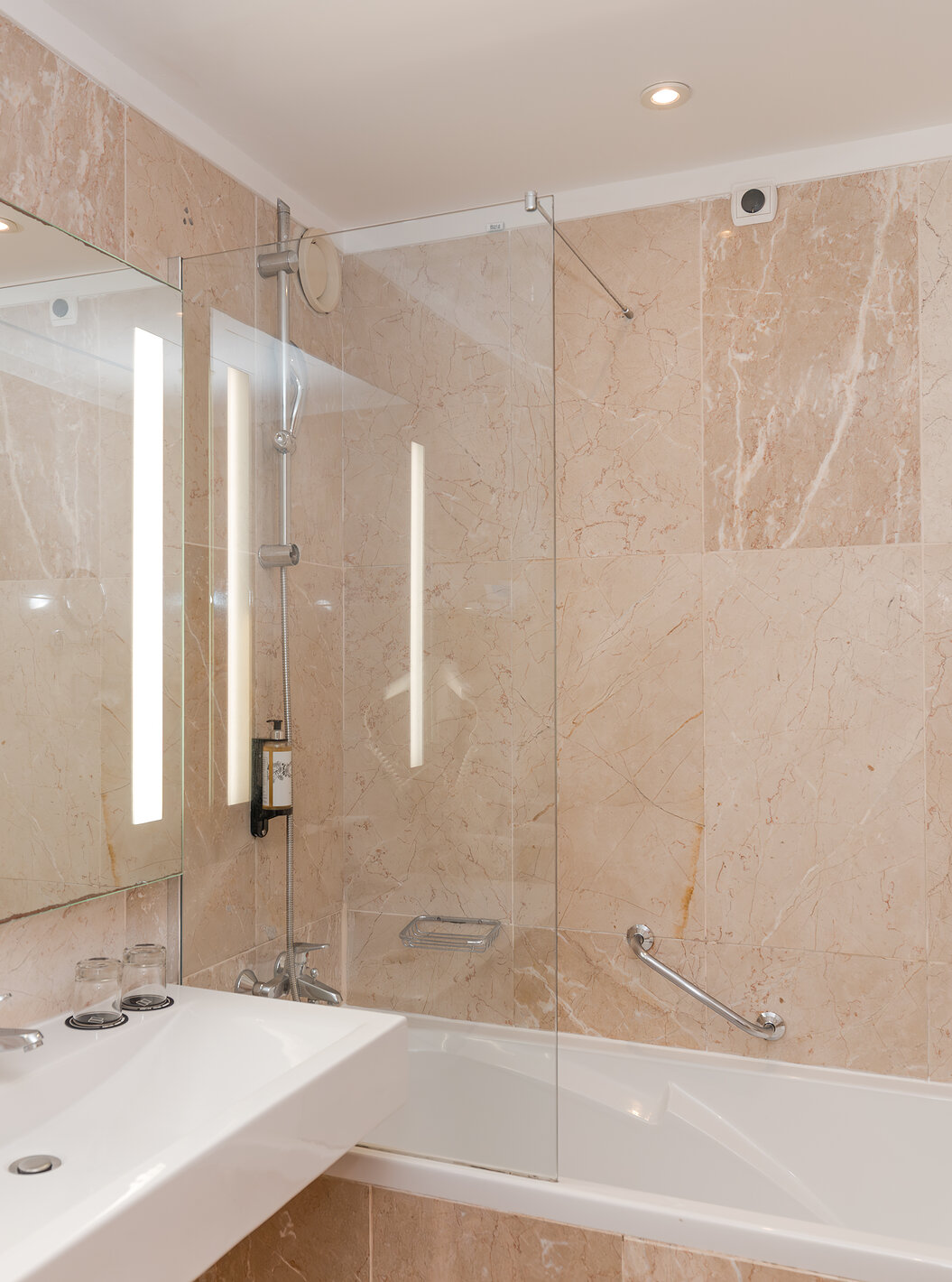 De Deluxe Tuinzicht van Pestana Viking heeft een badkamer met wastafel, grote spiegel en bad met douche