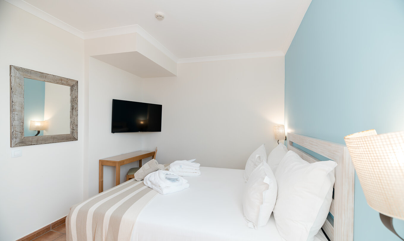 De T2 Suite van Pestana Viking heeft een kamer met tweepersoonsbed, tv en spiegel