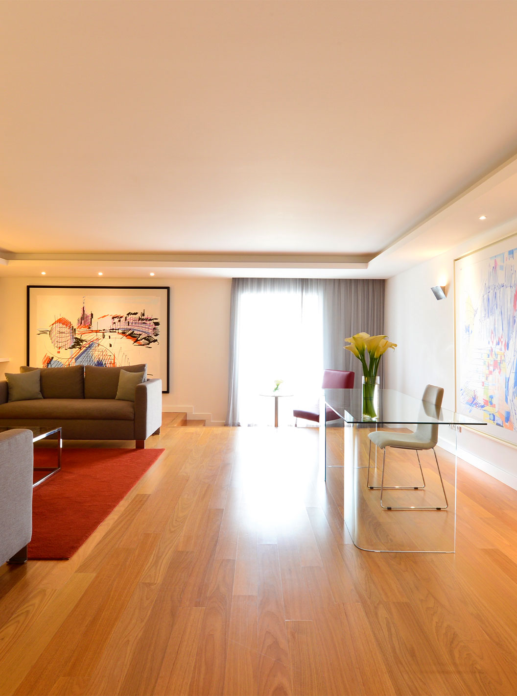 De Presidential Suite van Pestana Cidadela Cascais heeft een woonkamer met een glazen bureau, schilderijen en een bank