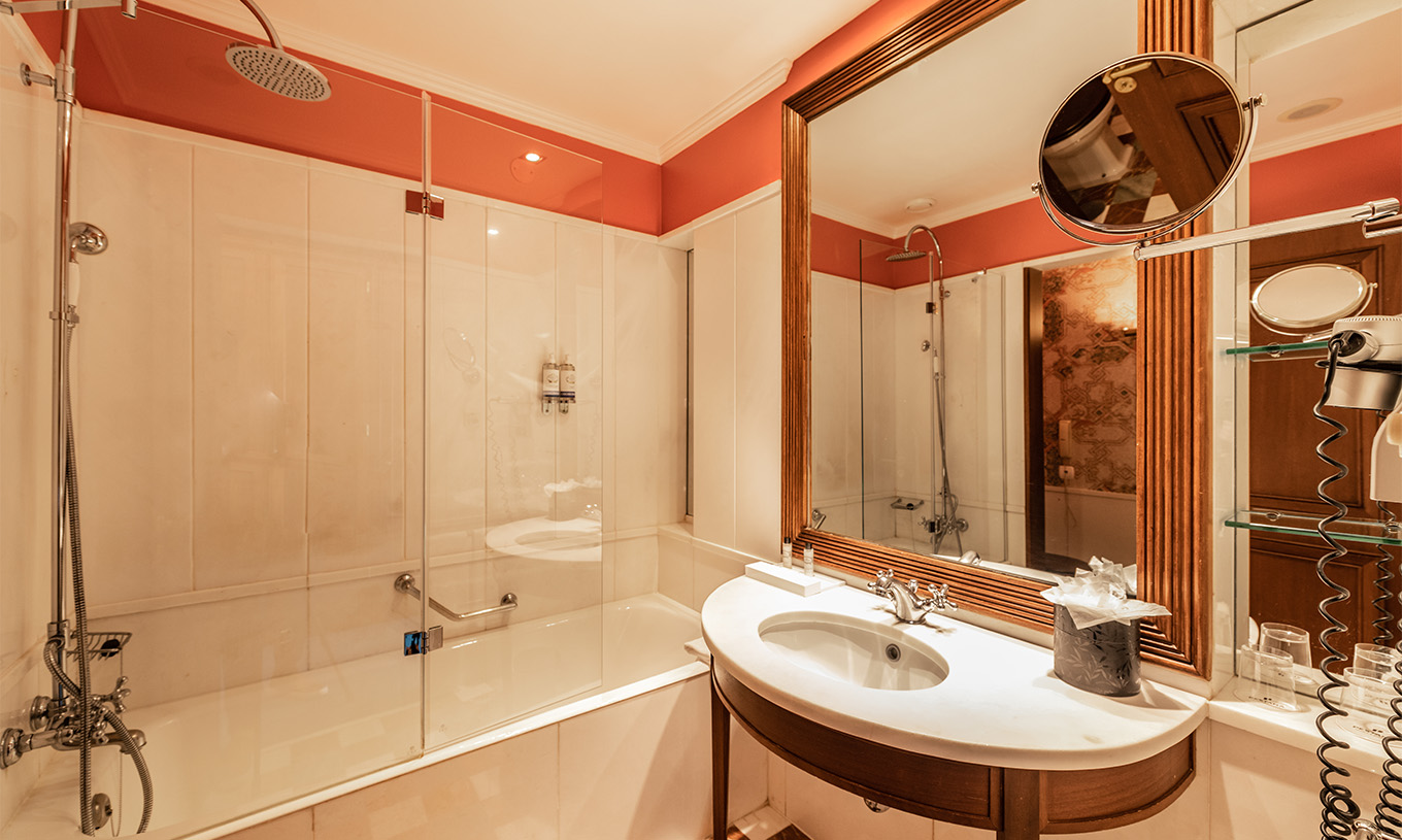 De Premium Balcony van Pestana Palace Lisboa heeft een badkamer met ligbad, wastafel met spiegel en vergrotende spiegel